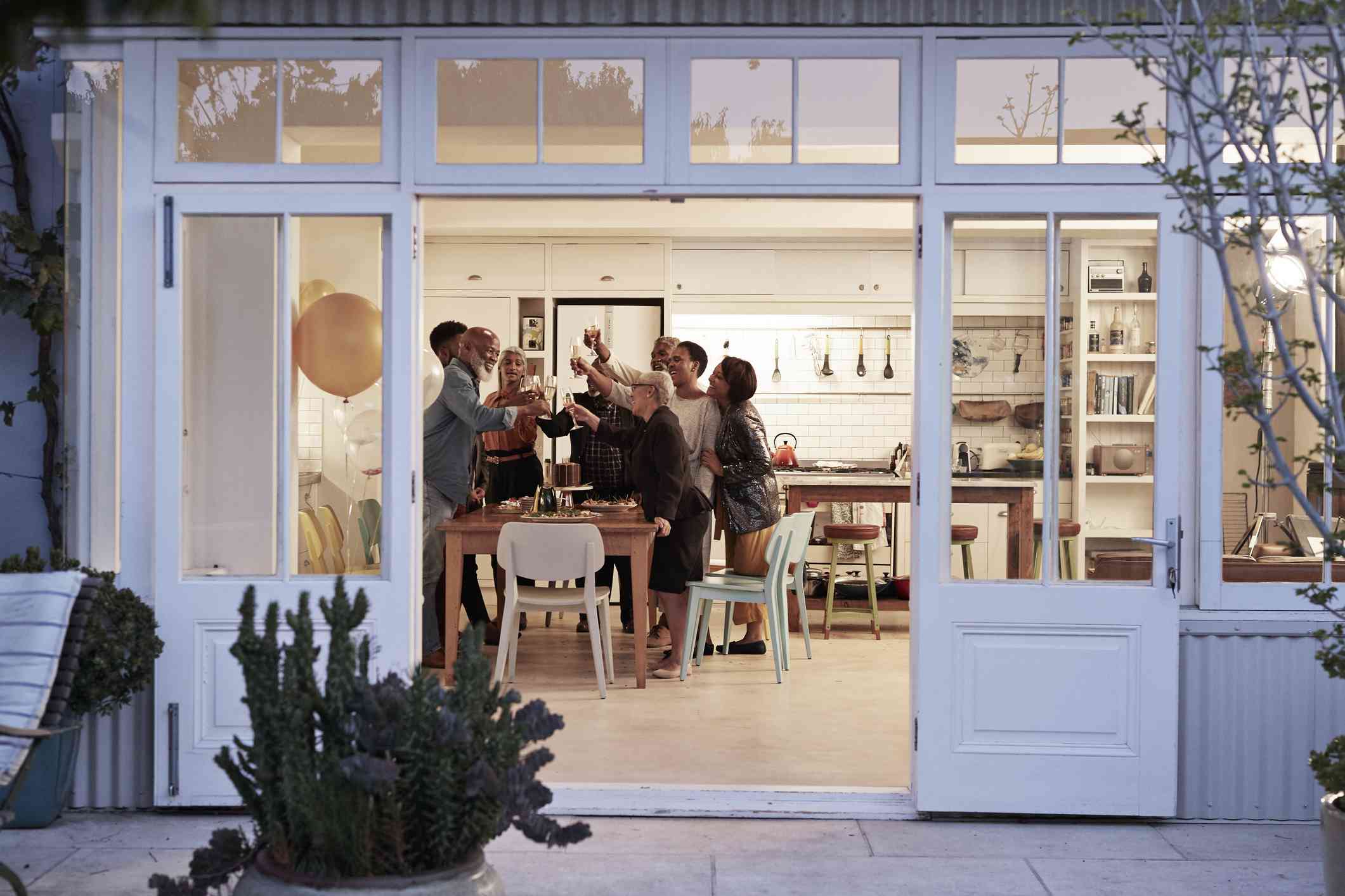 A large family makes a toast in their kitchen