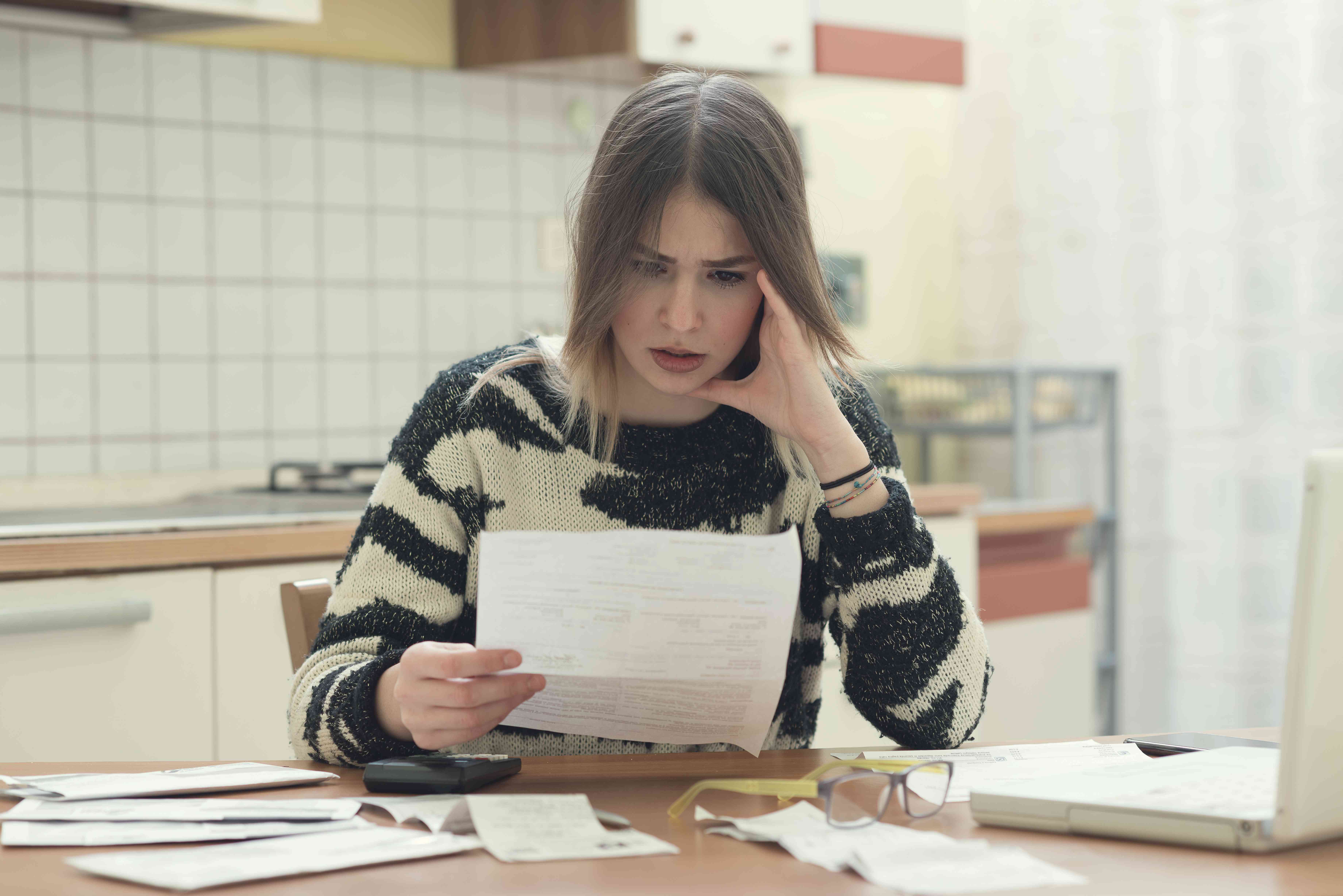 Stressed young woman looks at paperwork