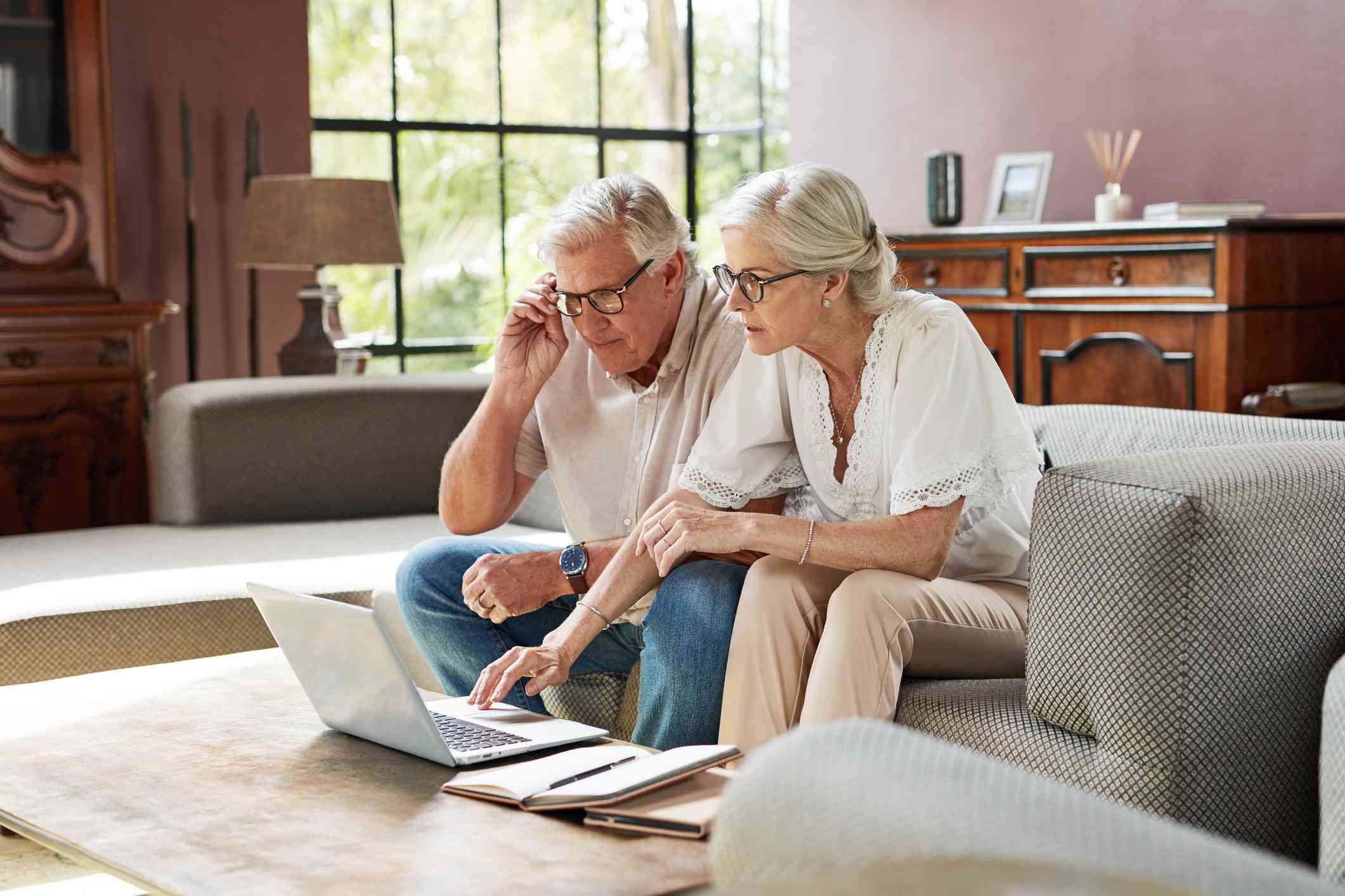 Older couple looking at computer together, doing research.