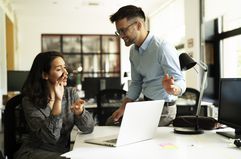 Two coworkers talking at an office desk