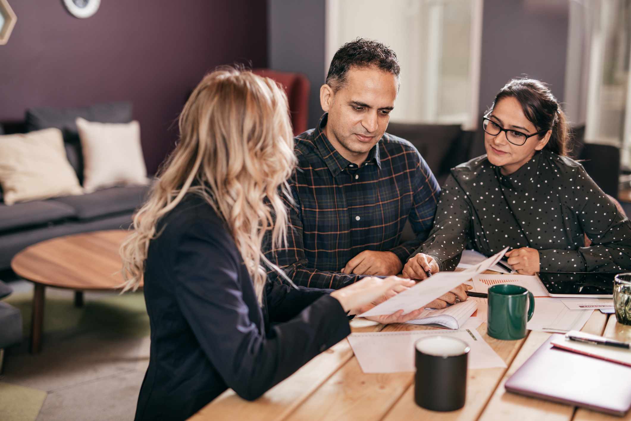 Middle-aged couple talking to a financial aid advisor about their child’s tuition costs