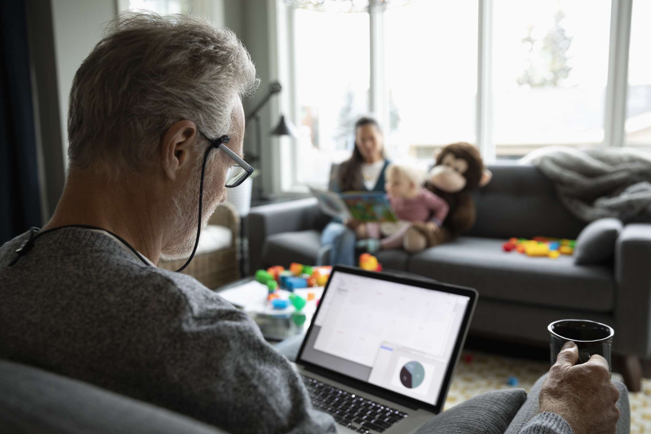 An older man looking up files on a laptop