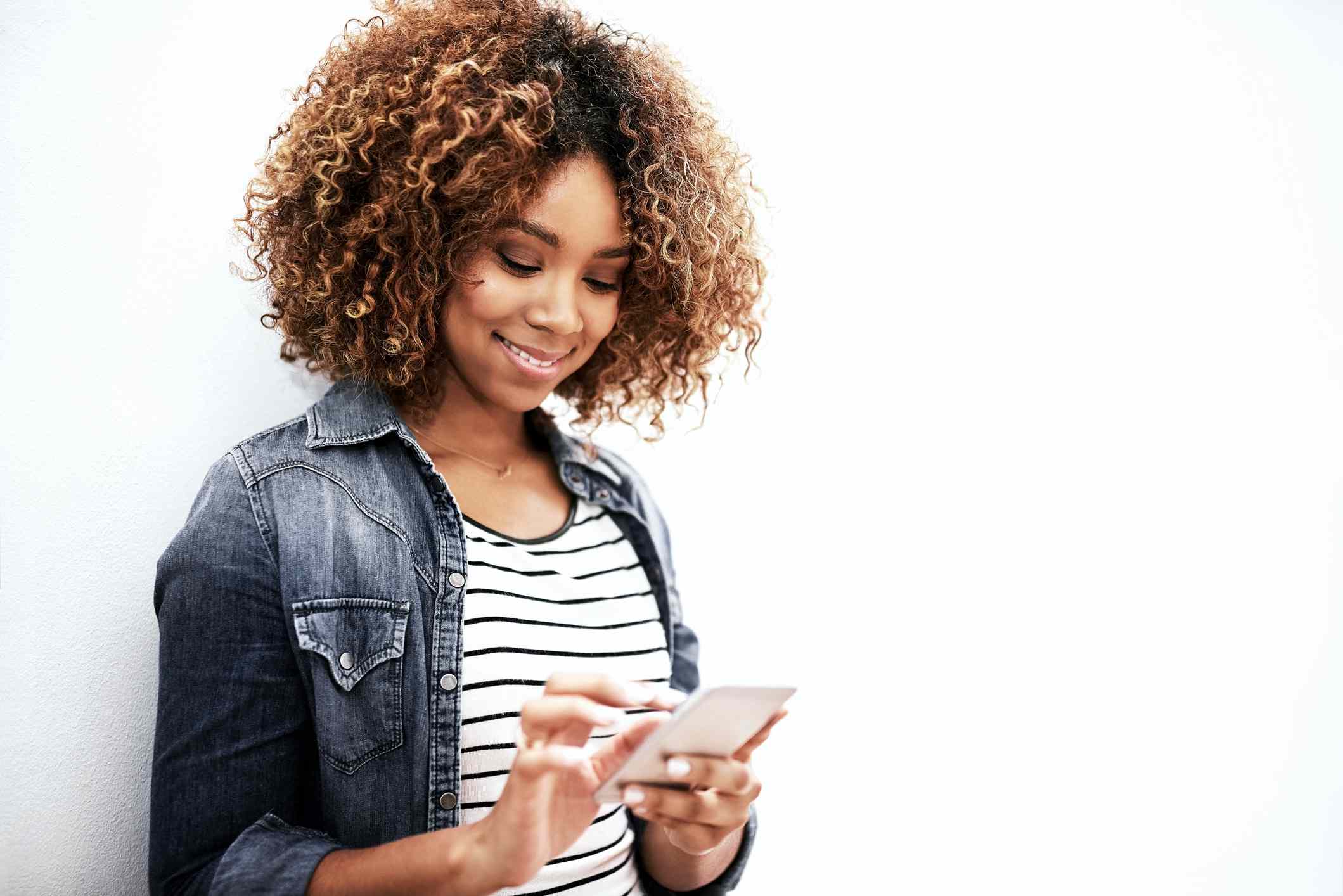 Woman holding a smartphone and pointing at the screen