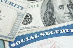 Social security cards laying on top of U.S. currency.