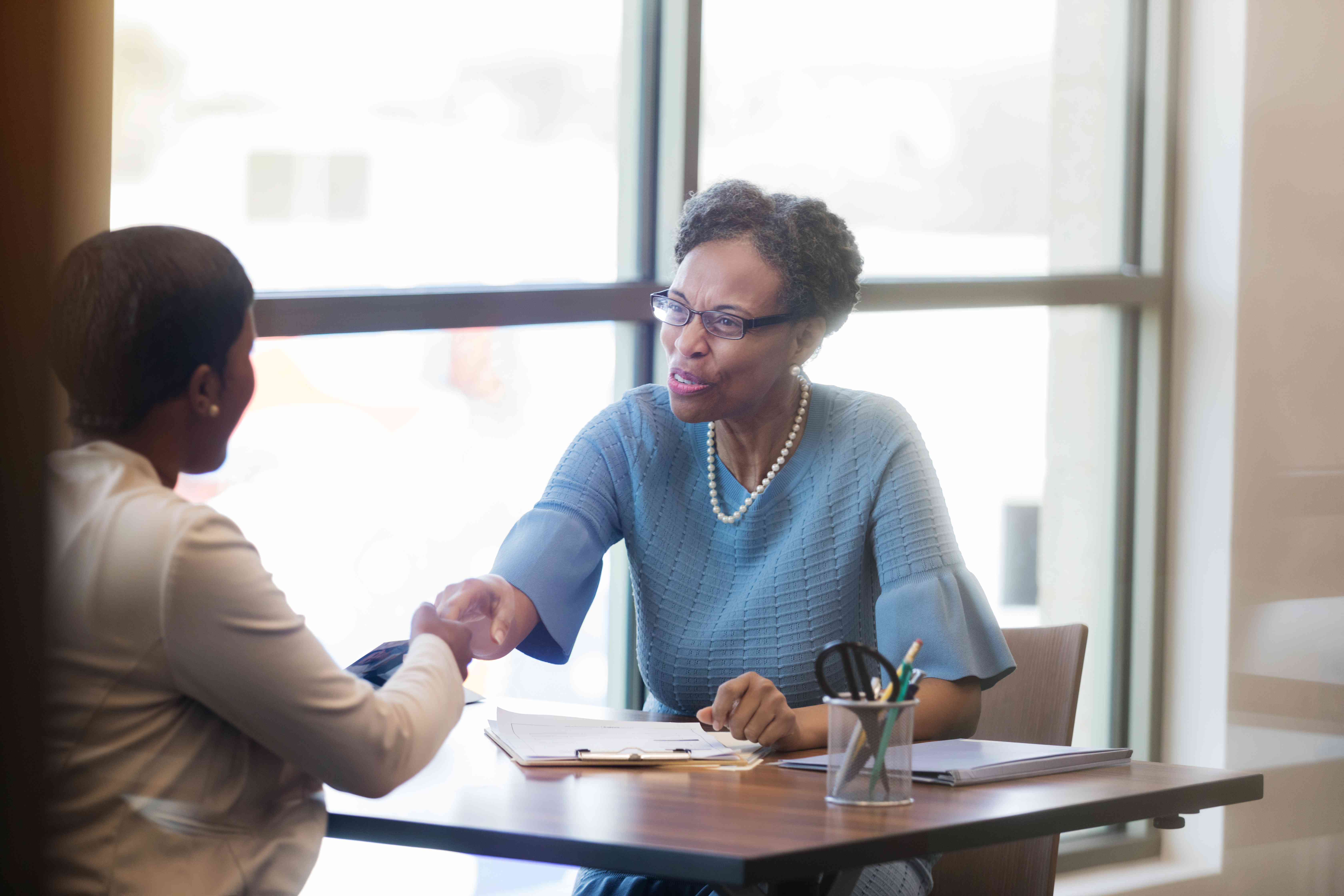 Loan officer shakes hand with customer upon mortgage renewal deal