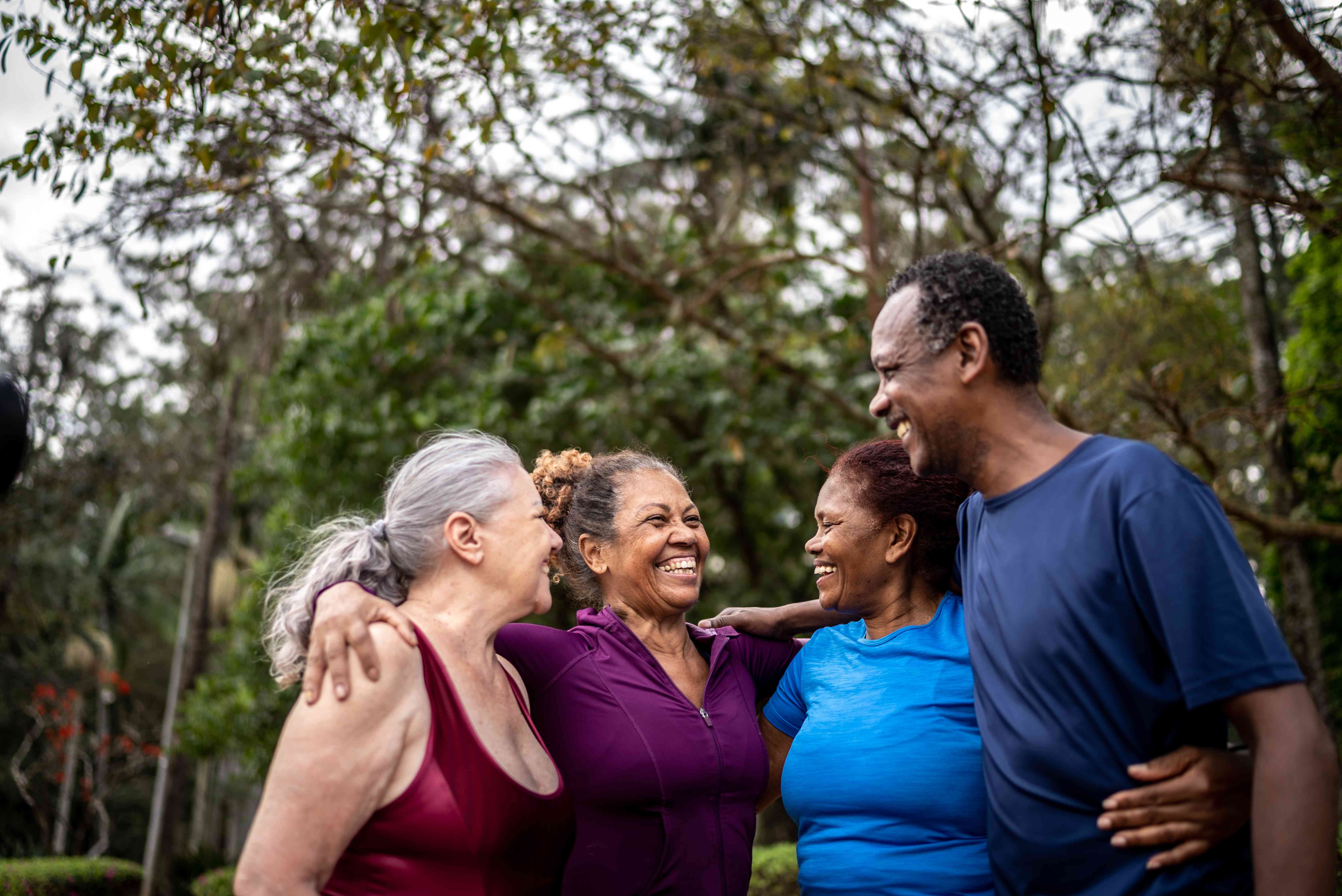 Happy senior friends embracing in a park