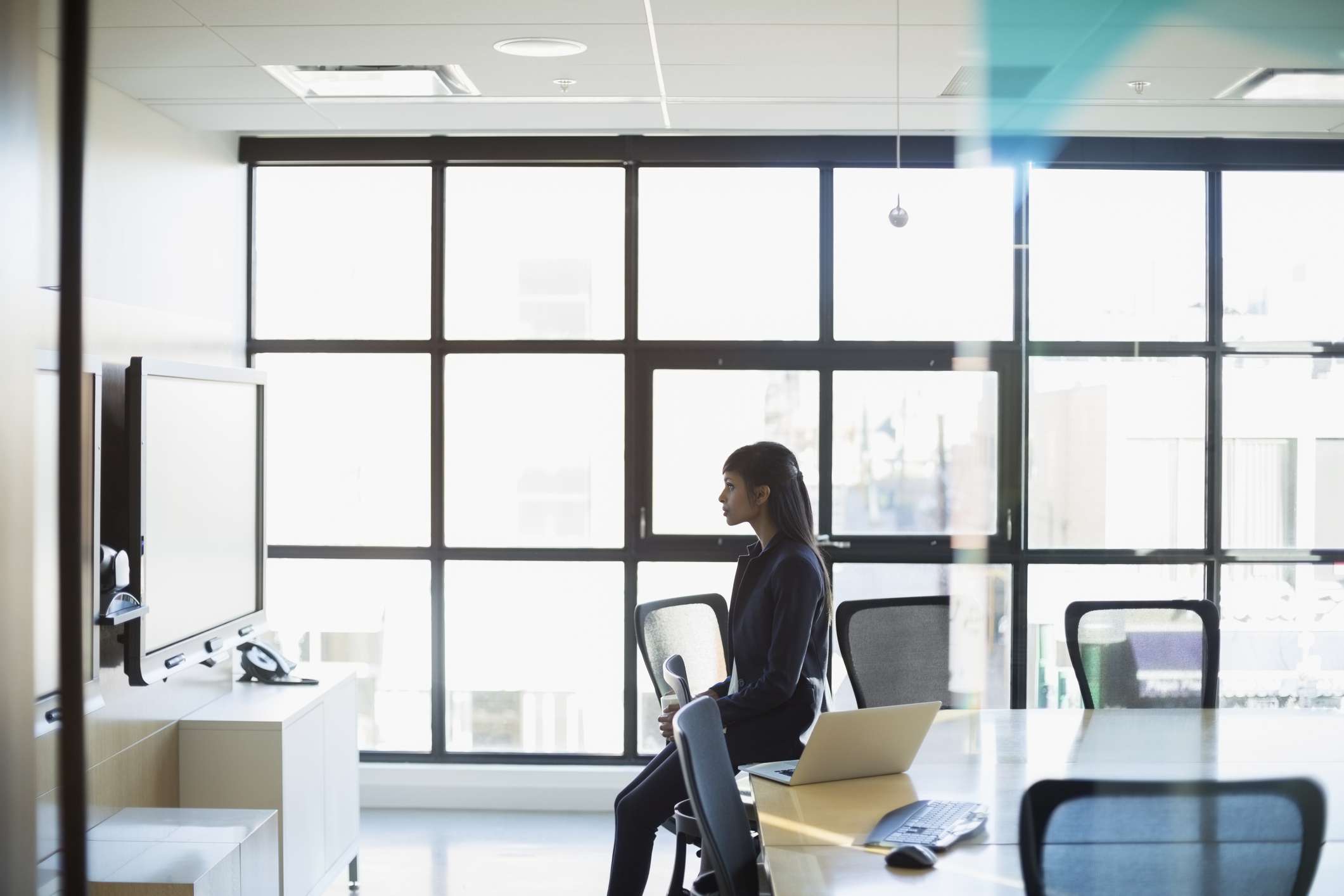 Businesswoman watching screen in conference room.