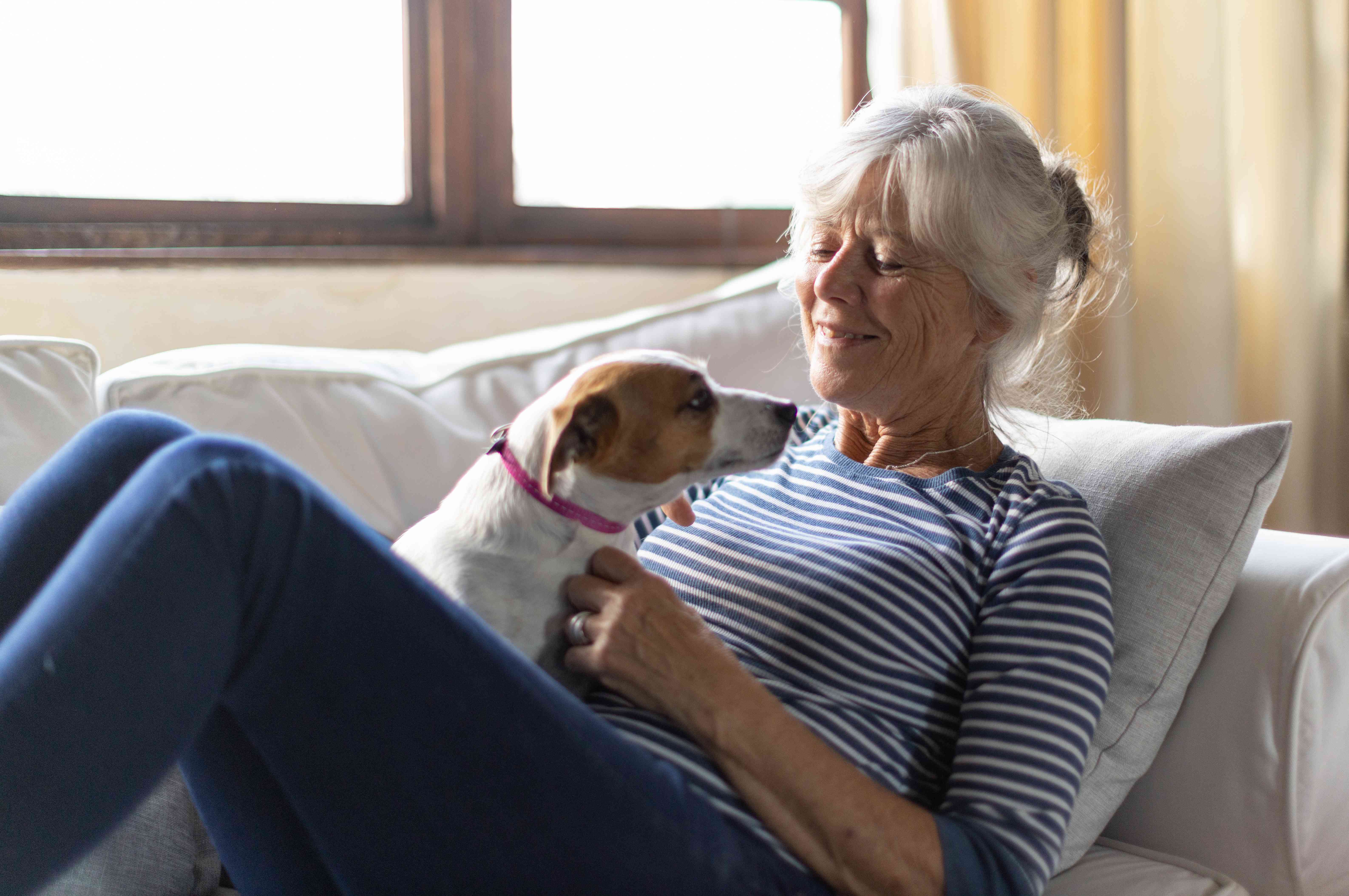 A woman pets a dog.