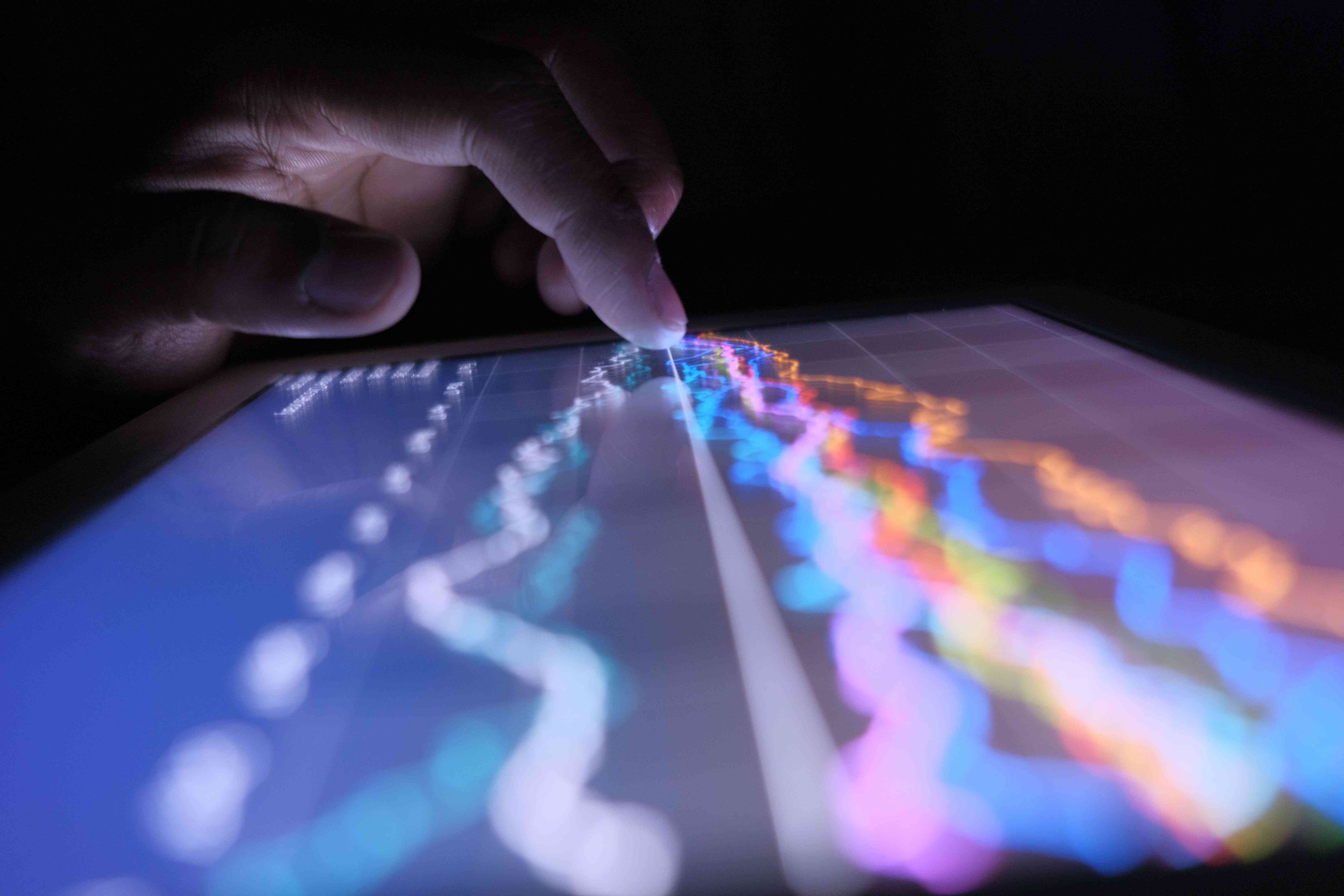 Hand on a Screen with Market Chart