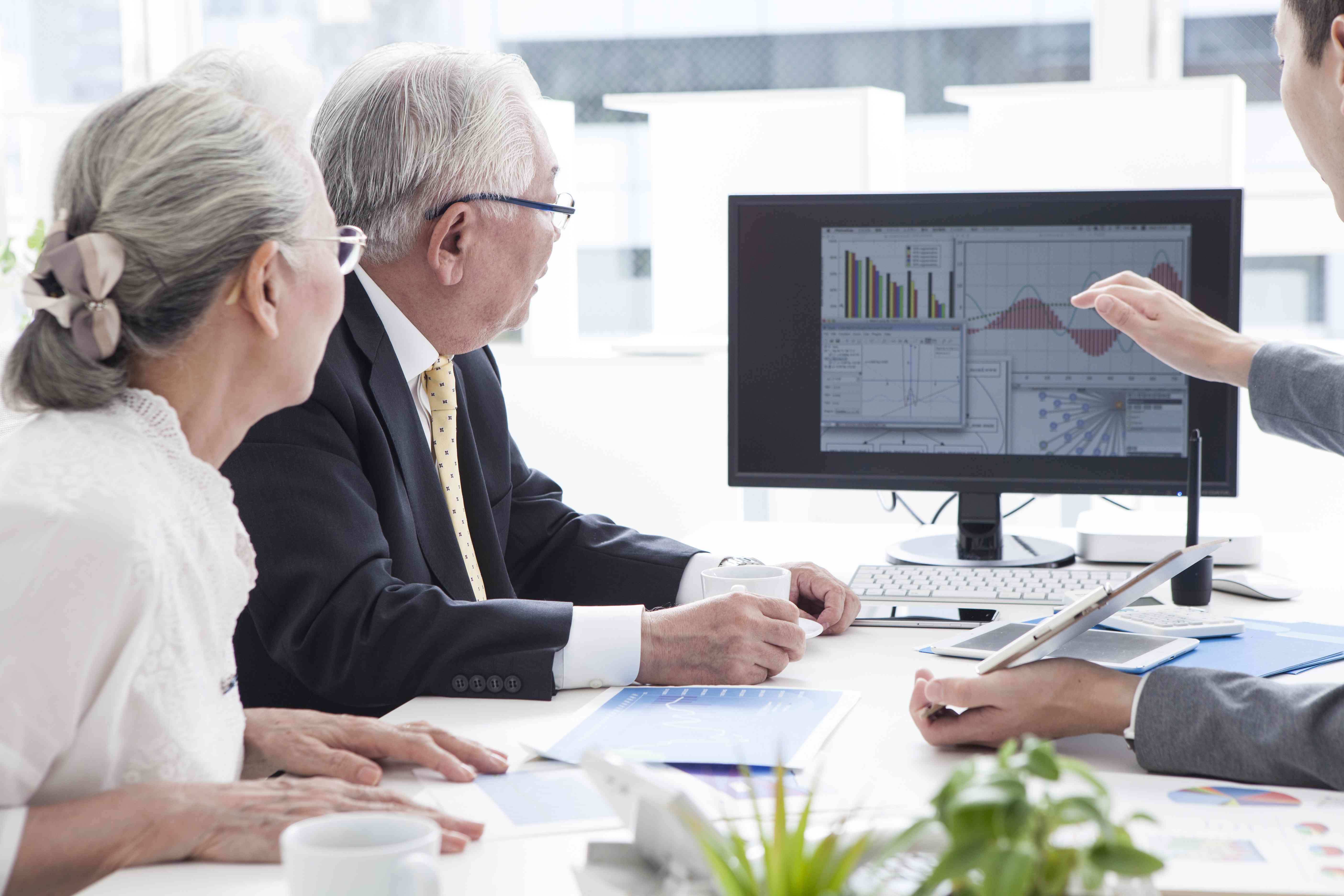 Older couple looks at charts on a screen