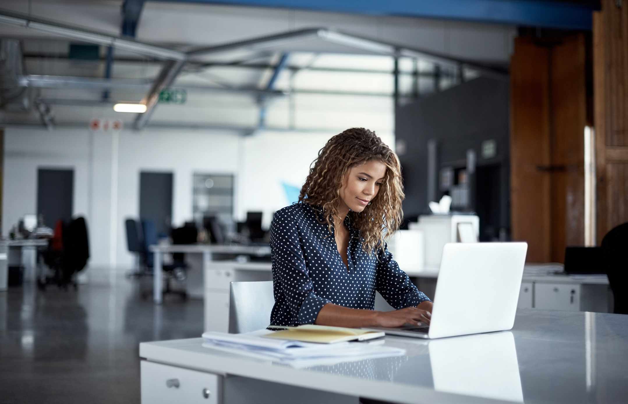 A woman works at a laptop.