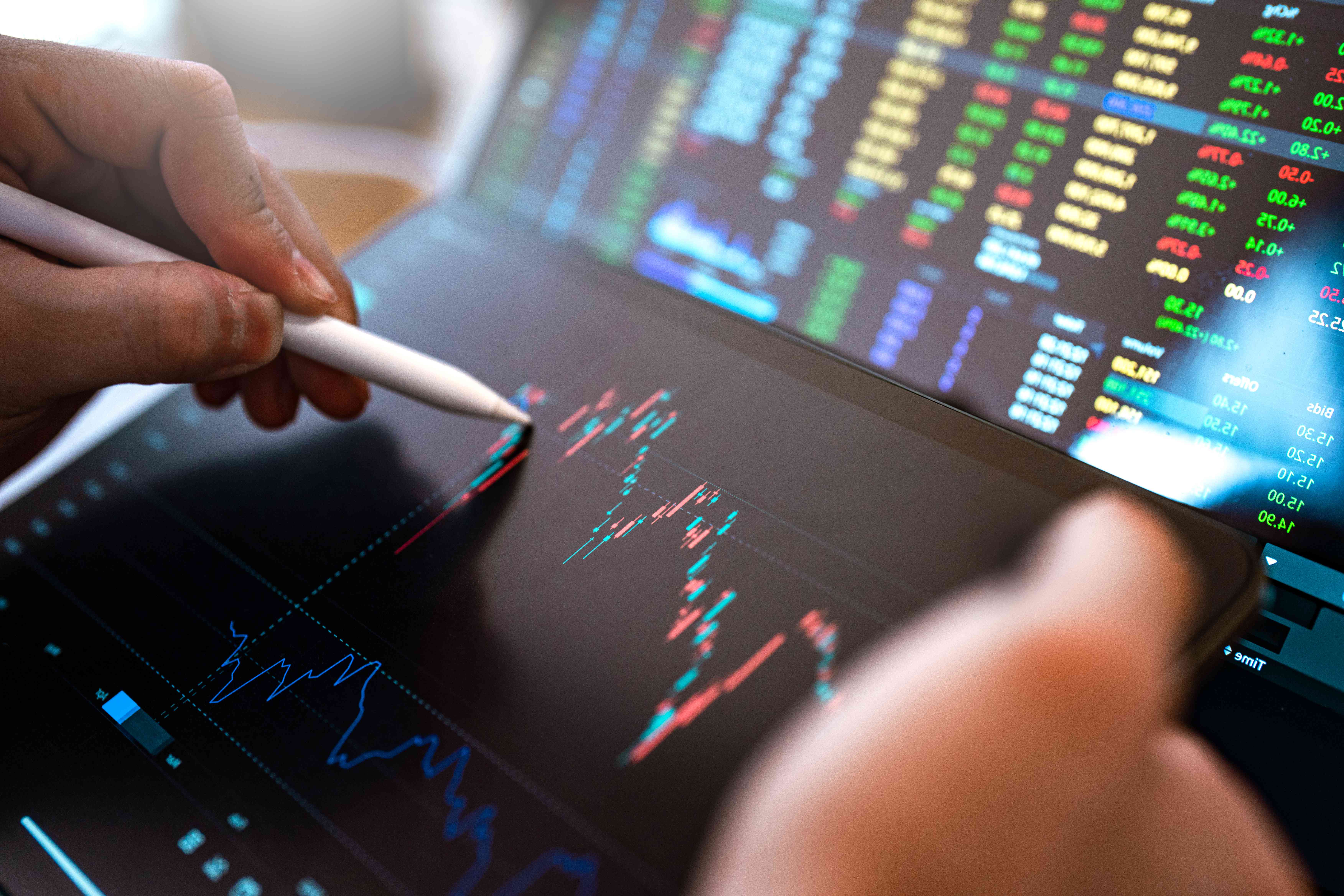 Market analysis with Digital Monitor focus on tip of finger.