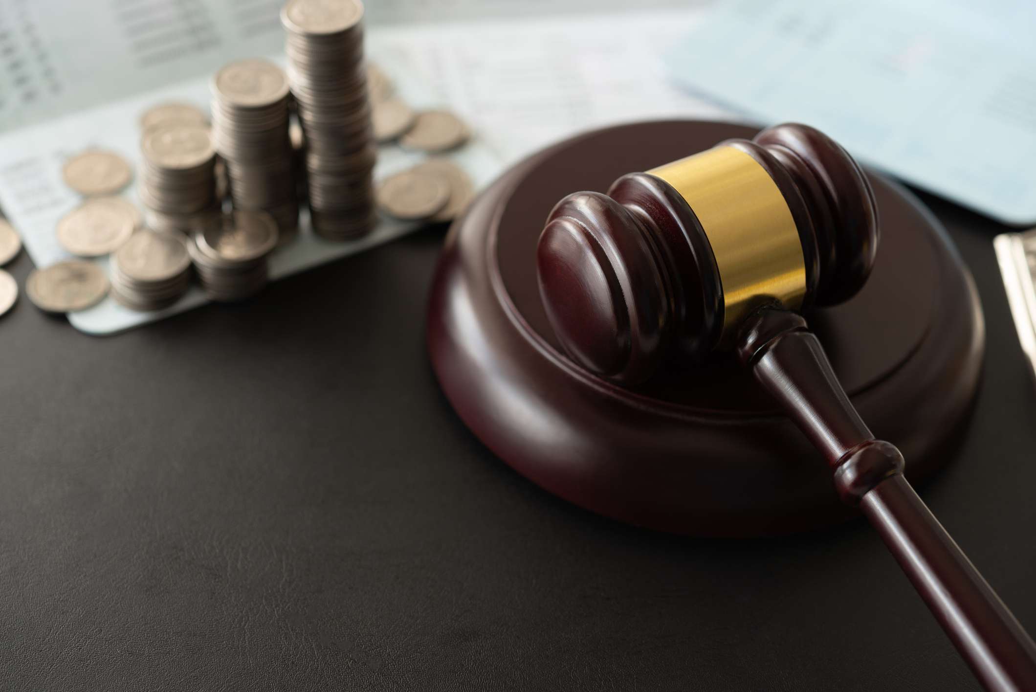 A gavel next to gold coins