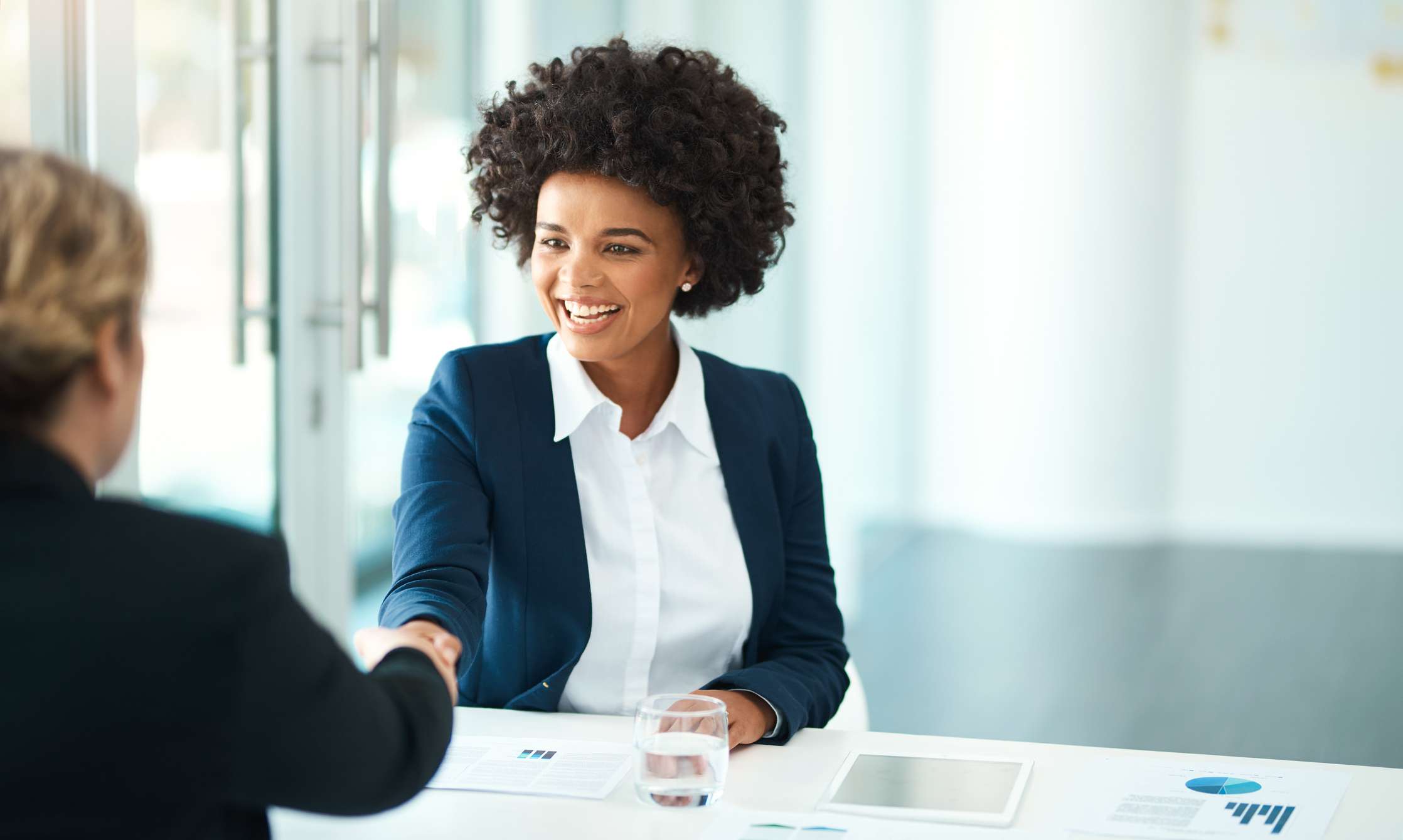 Two people shaking hands in an office.