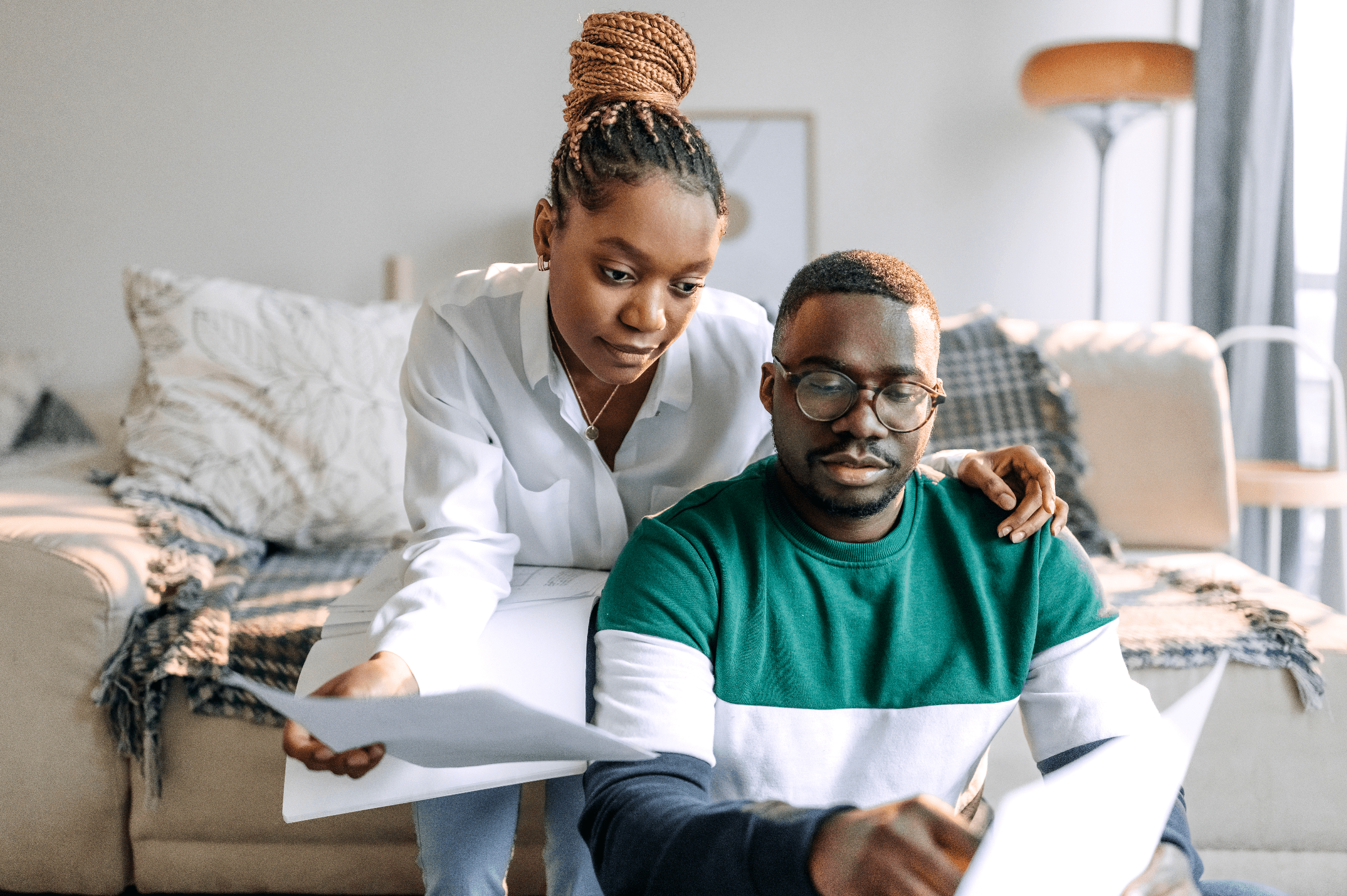 Young Black couple at home looking together at financial documents