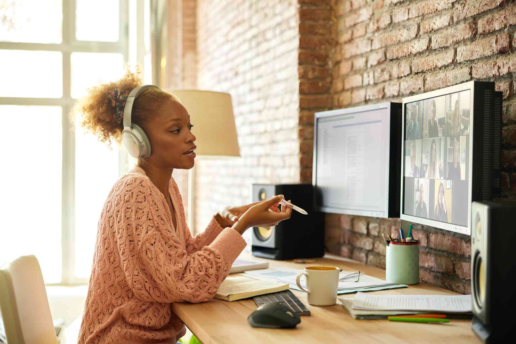 Young businesswoman discussing on video call. Female entrepreneur using computers on desk. She is working from home.