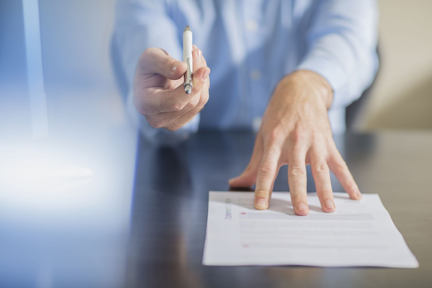 Person Sitting at Office Desk Presenting Ballpen and Contract