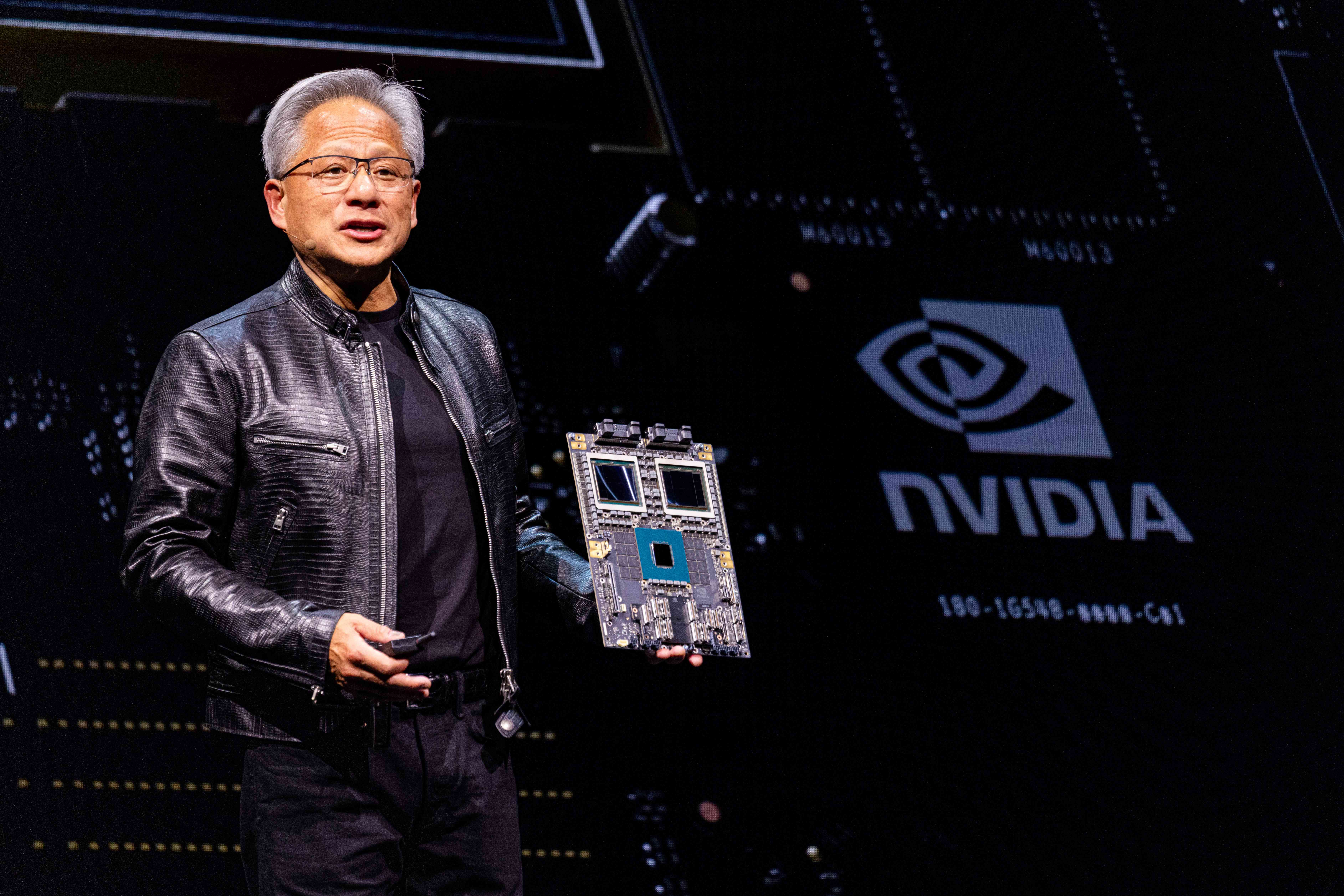 Jensen Huang, co-founder and chief executive officer of Nvidia Corp., speaks beside a company logo.