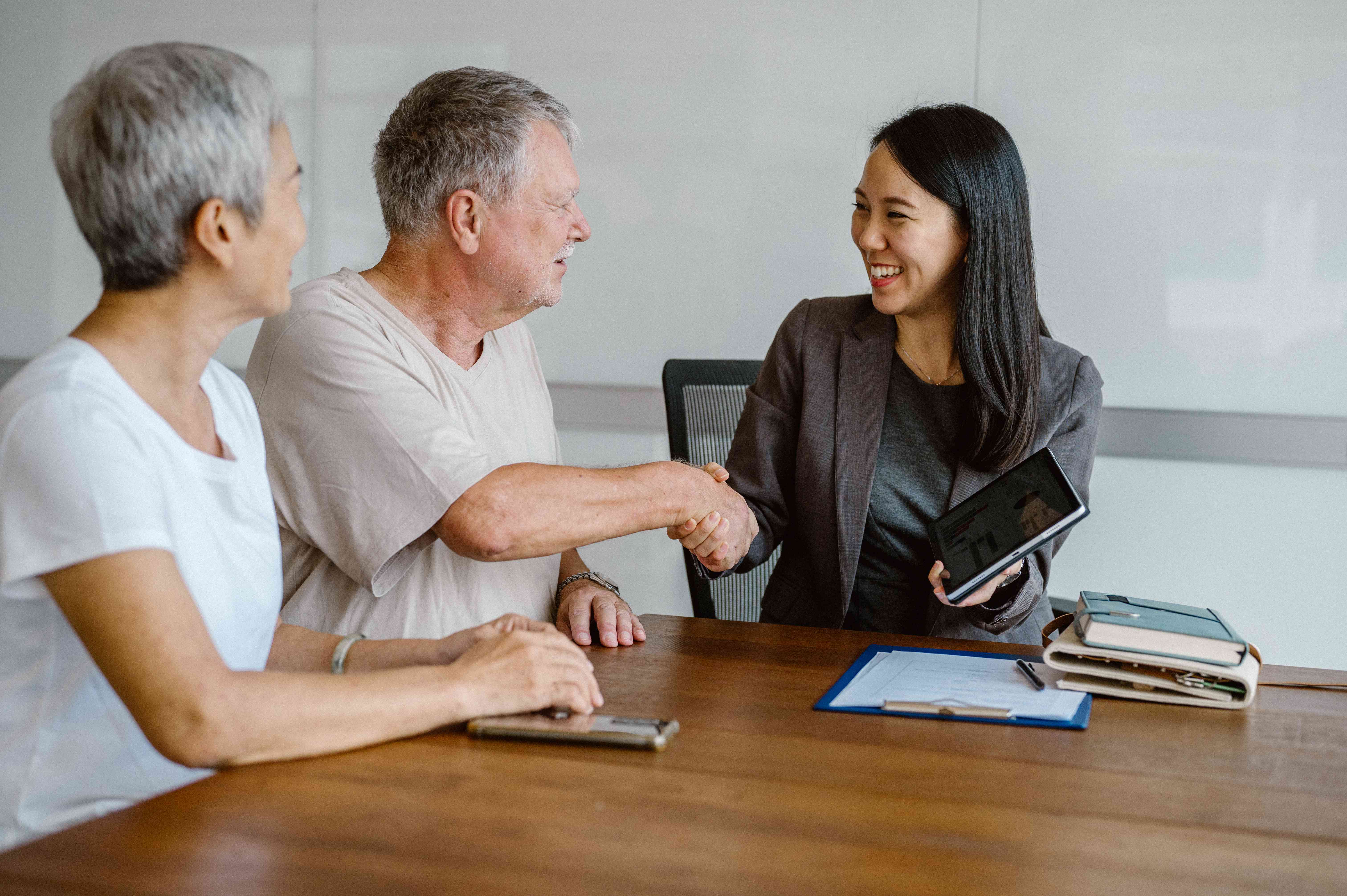 Couple shaking hand with female loan officer