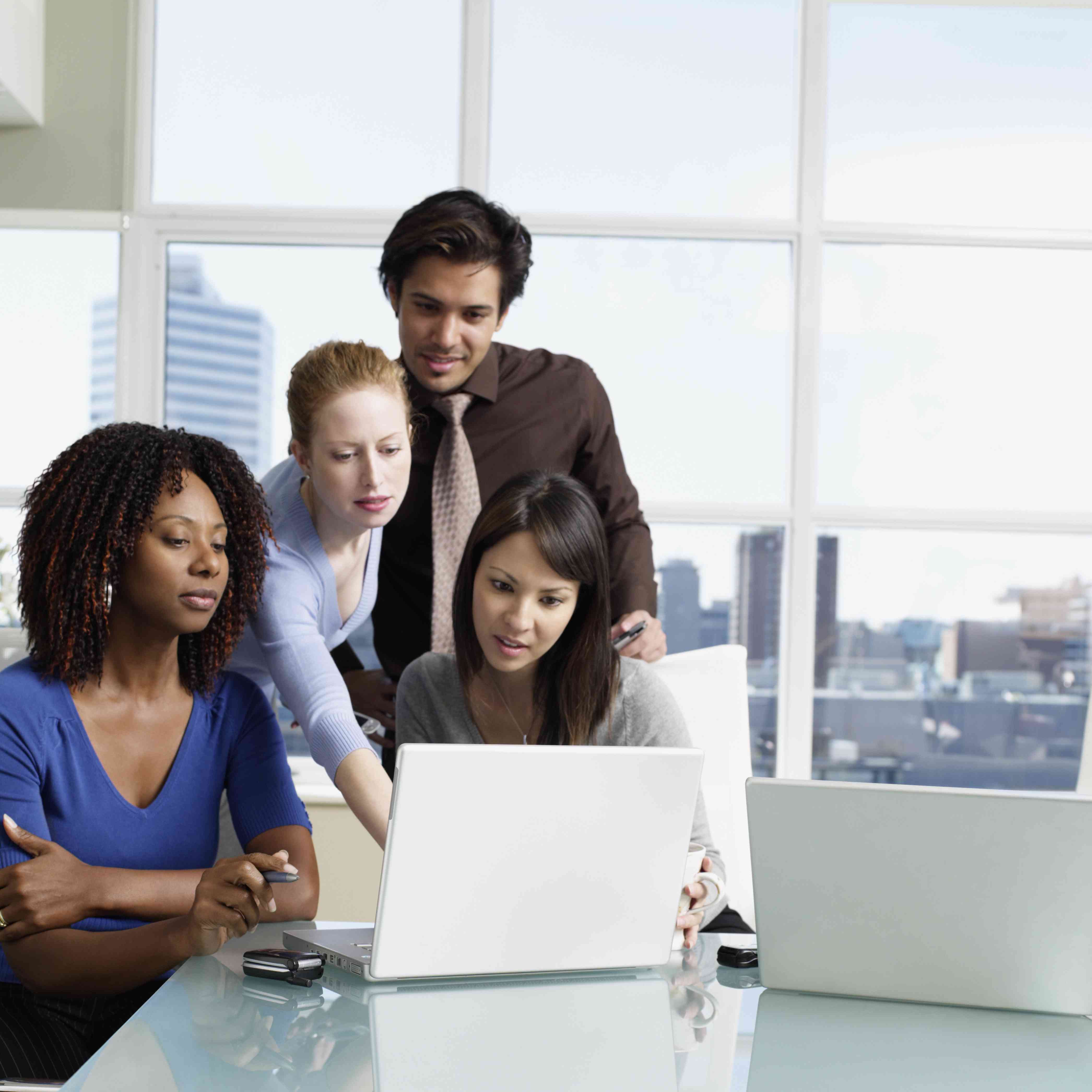 Business people in an office looking at a laptop