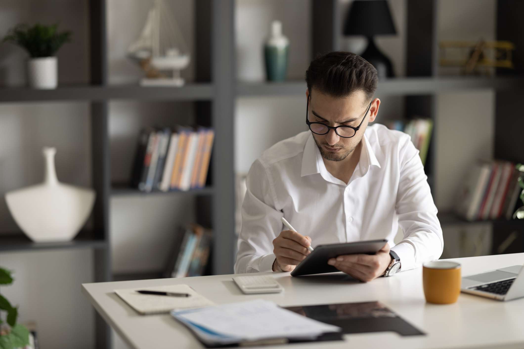 A man sits at a desk with paperwork.