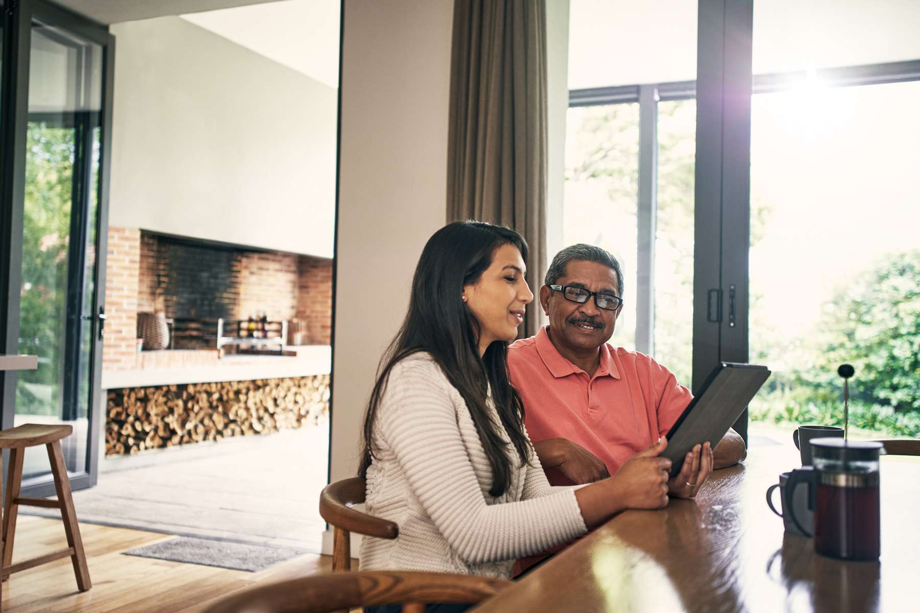 Adult woman using a laptop with her father at home