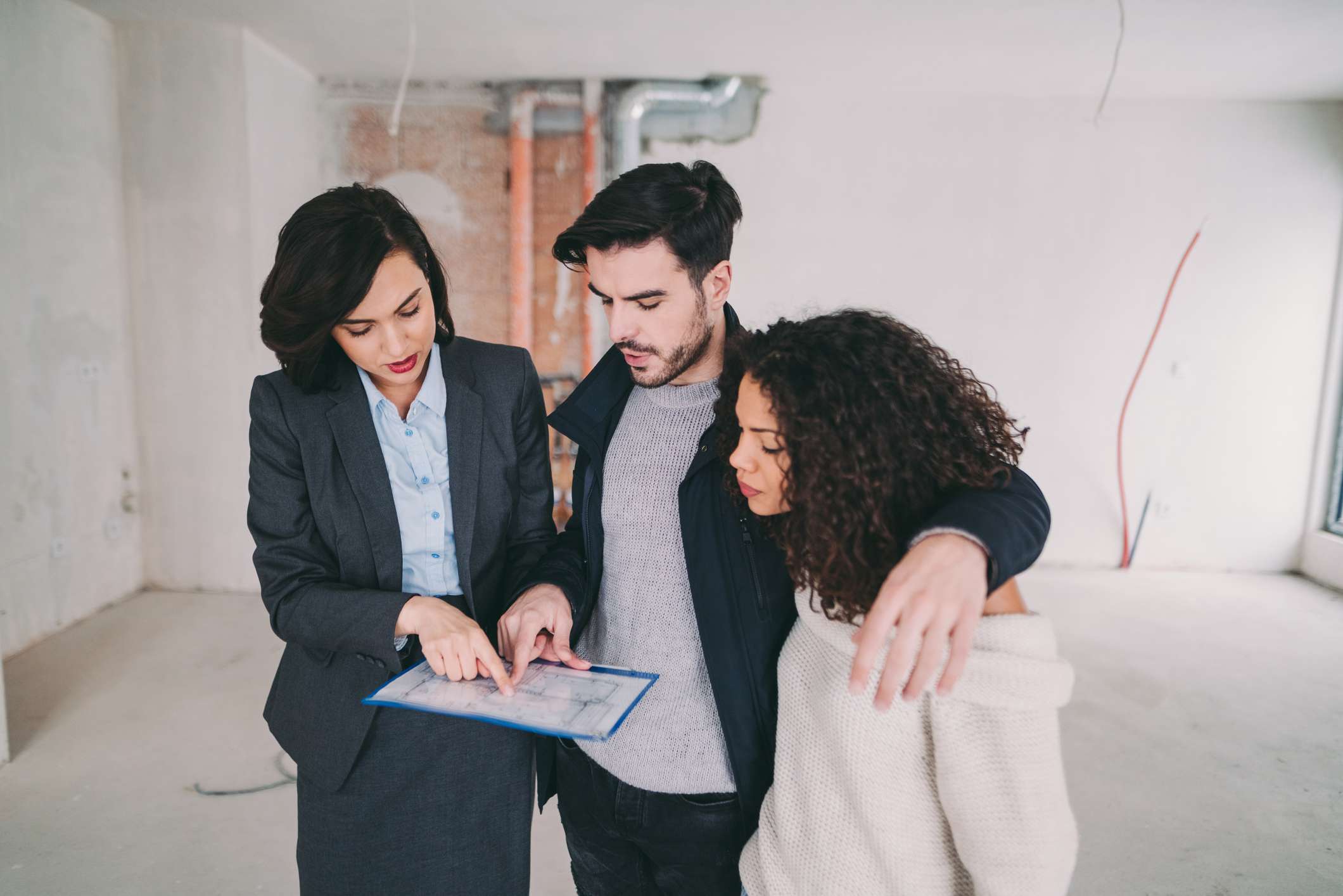 Real estate agent showing condo for sale to young couple