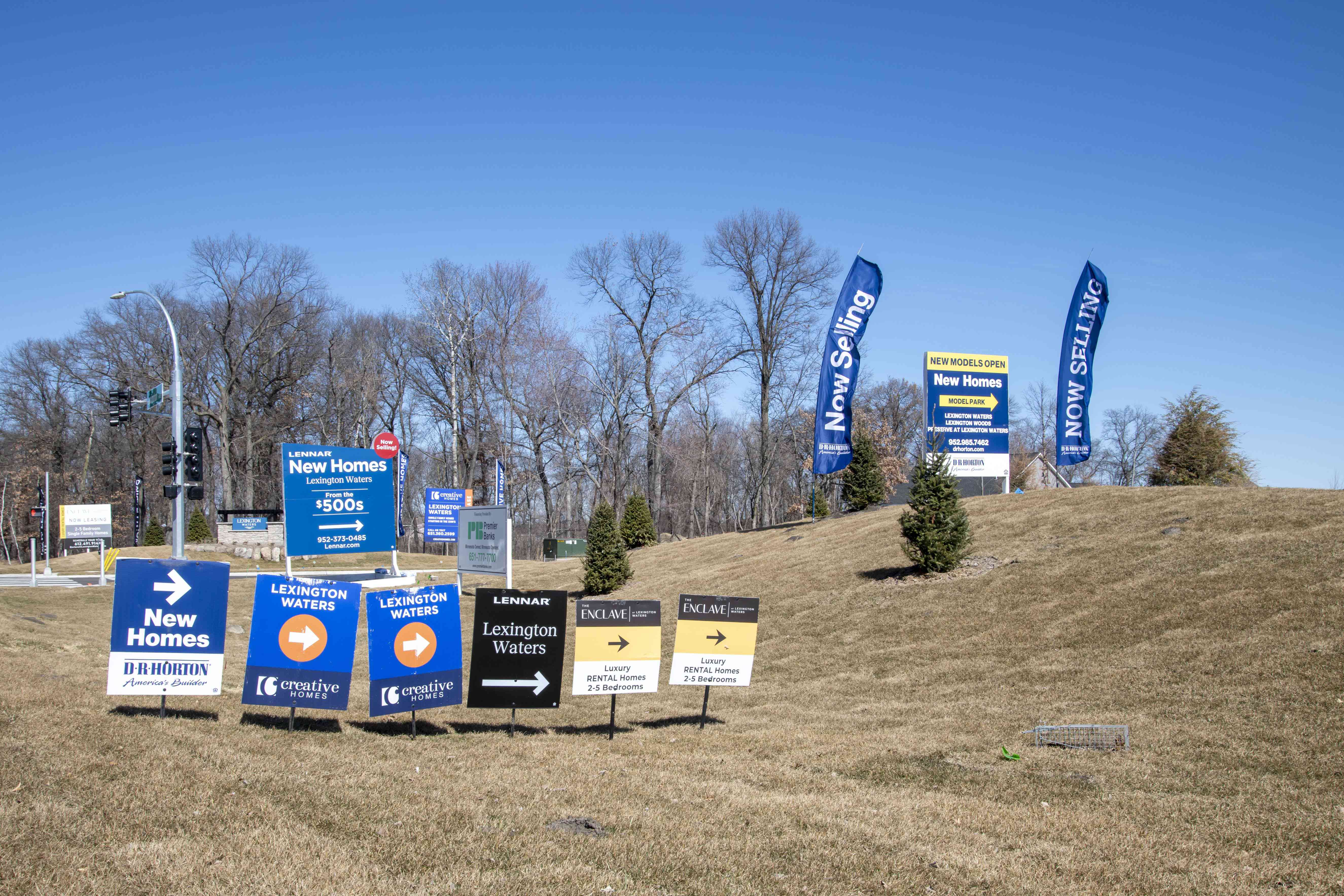 a cluster of homes for sale signs