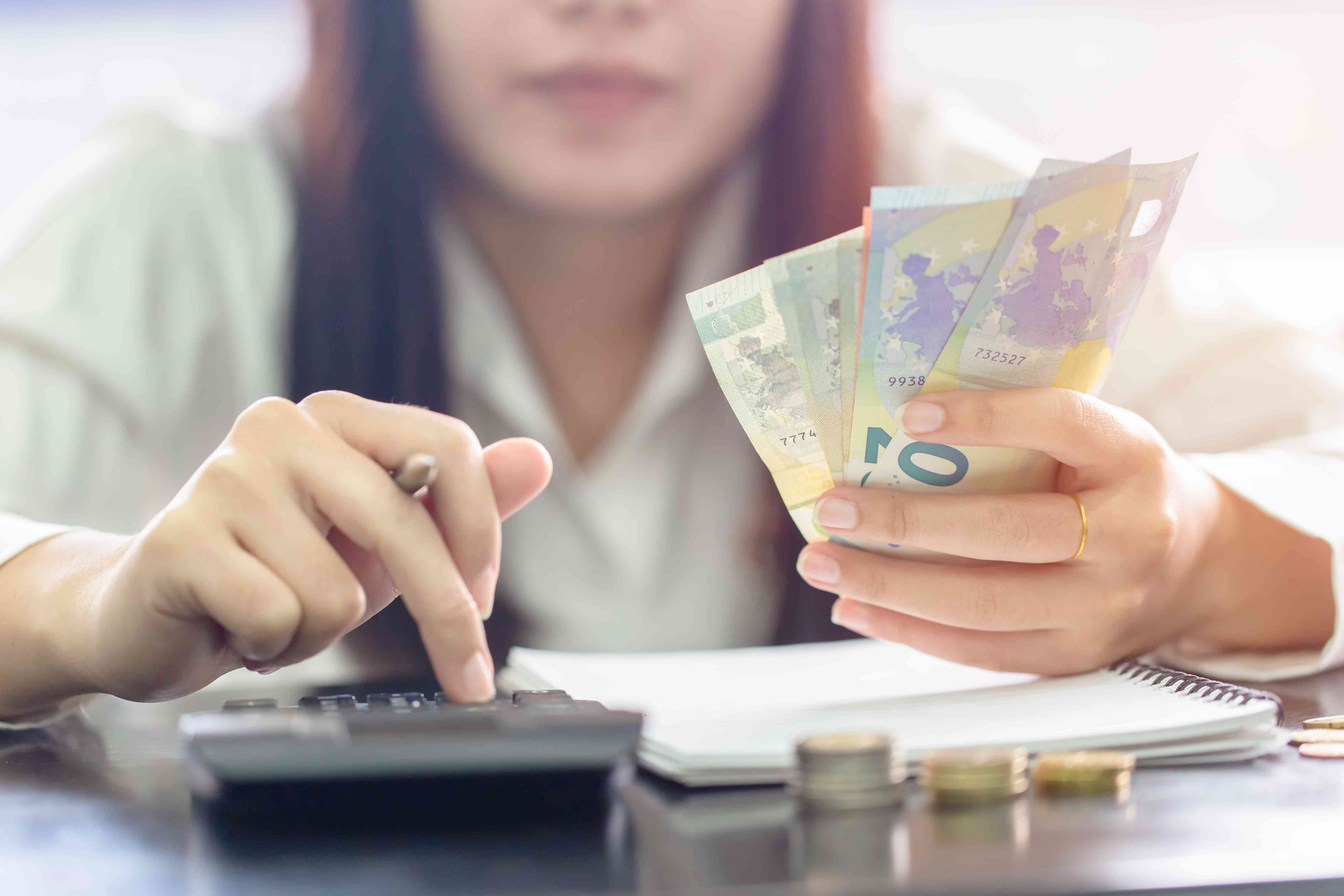 Woman counting money in Euro banknotes