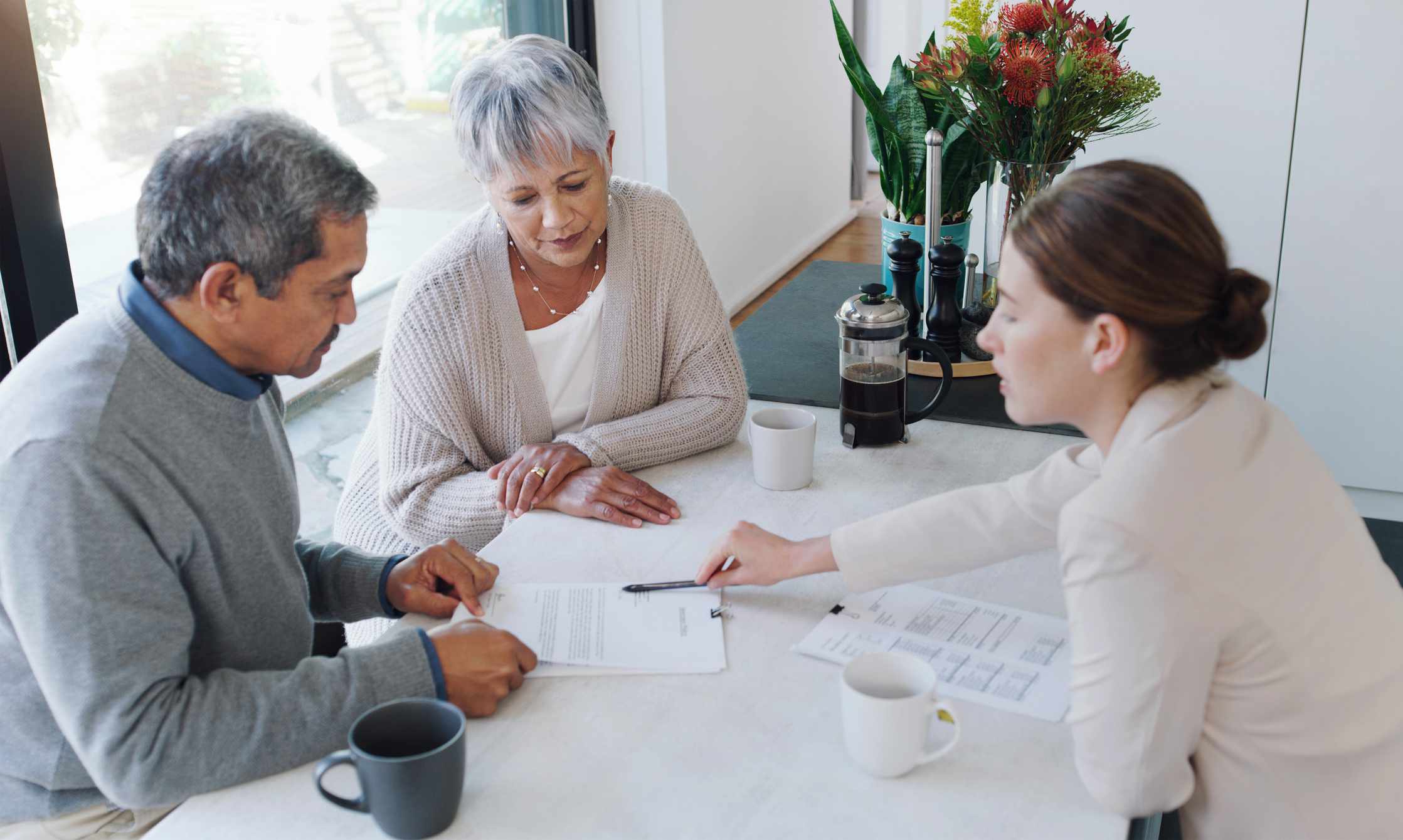 A couple reviews paperwork with an executive.