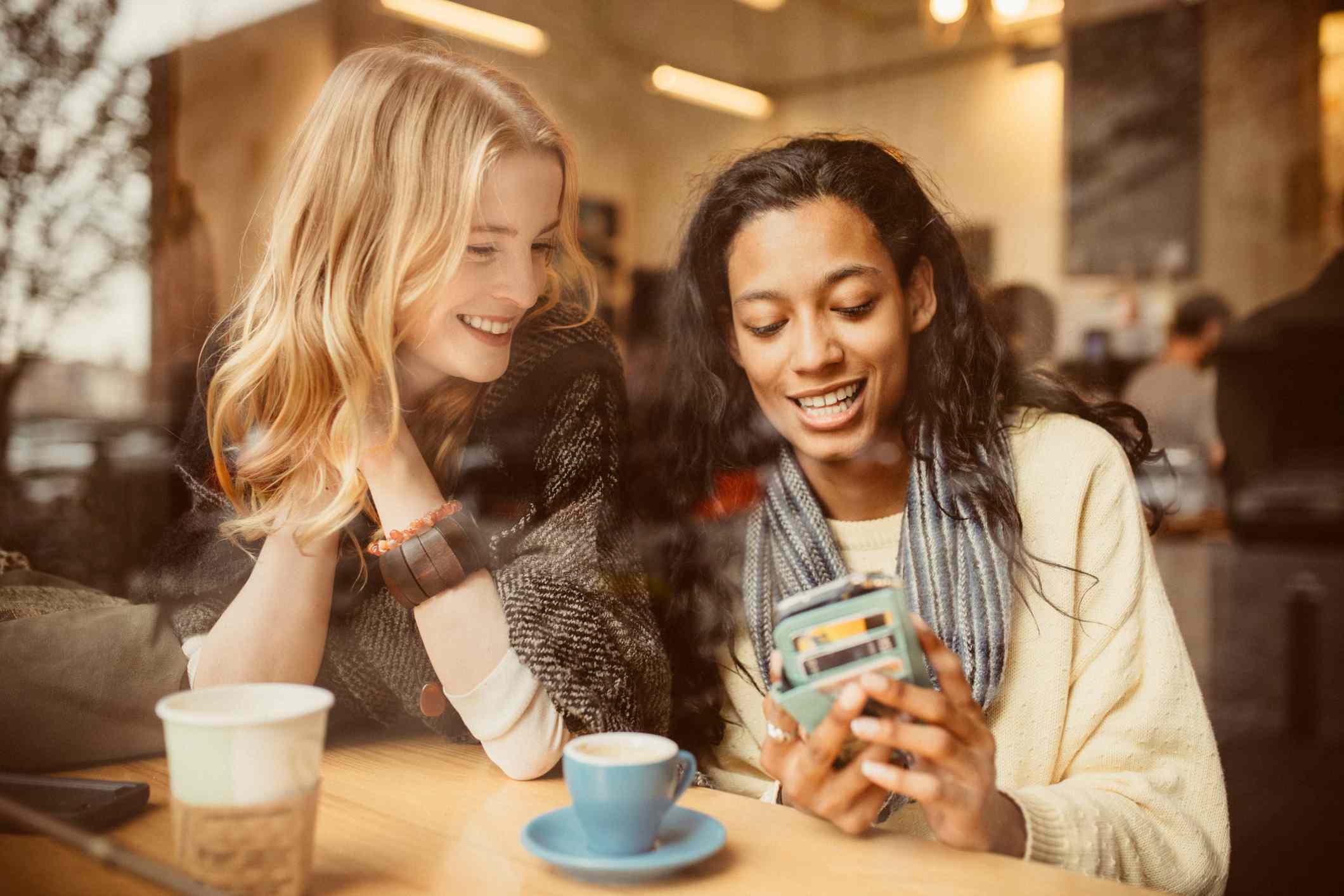 Two women pay for coffee with a credit card.