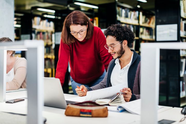 Woman looking over man’s papers