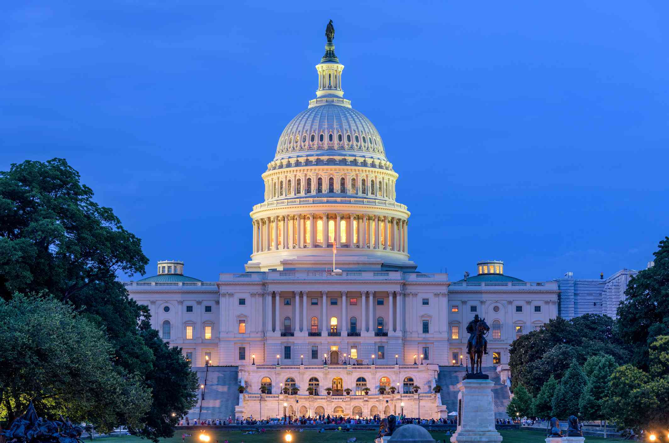 Summer Night at Capitol Hill - A dusk view of west-side of the U.S. Capitol Building, as a small crowd gathering around a summer concert at front, Washington, D.C., USA.