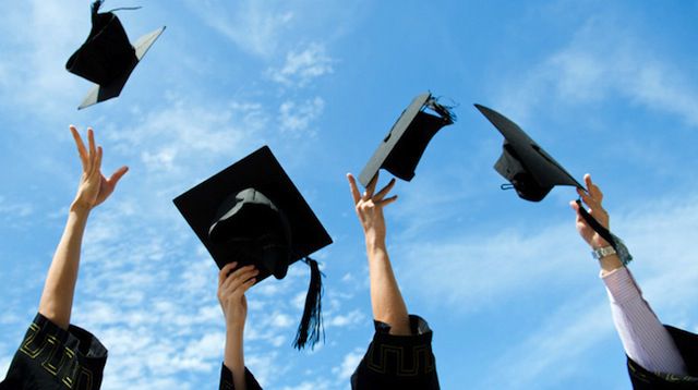 Graduates throwing mortarboards in the air