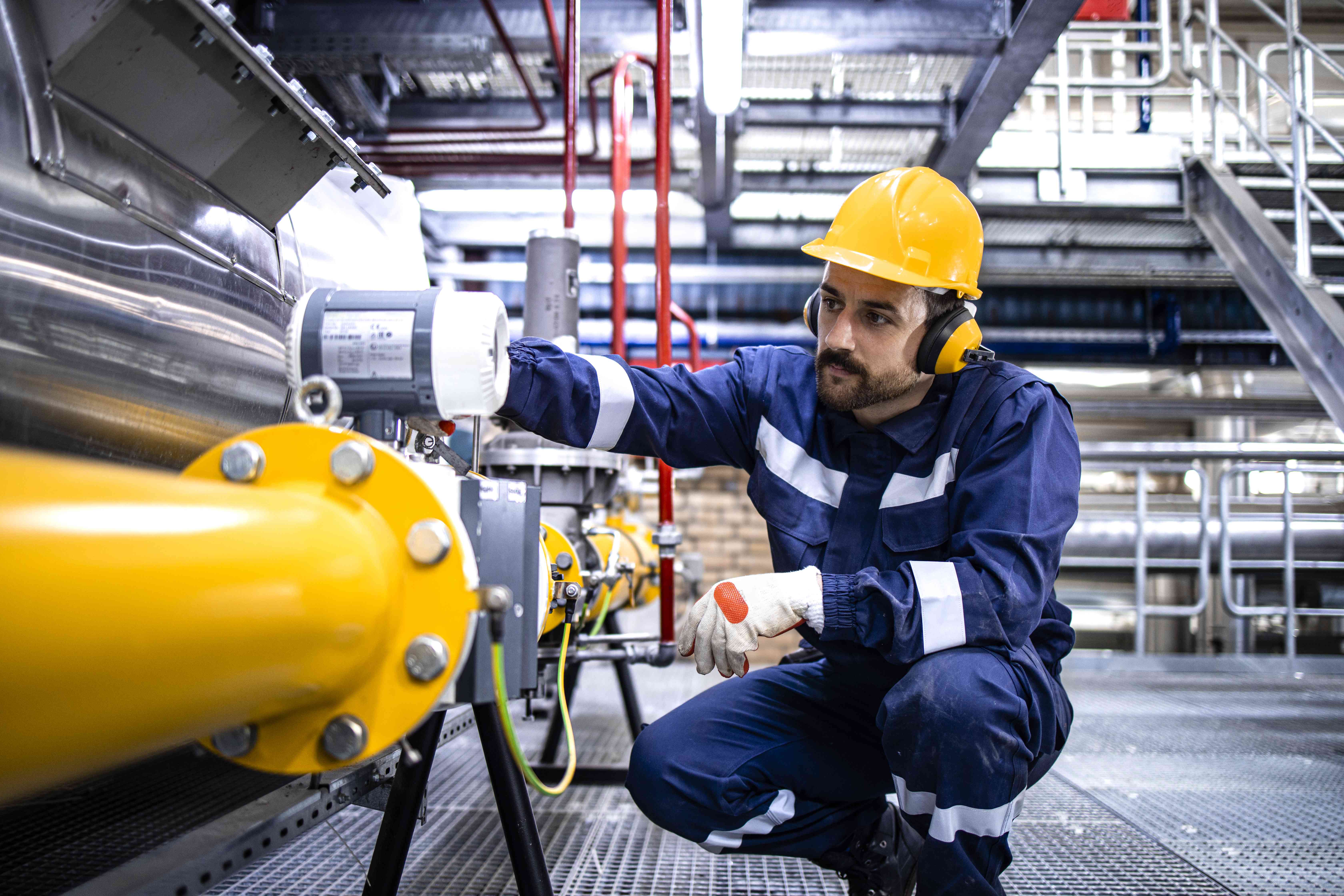 Refinery worker checking a pipeline for natural gas production