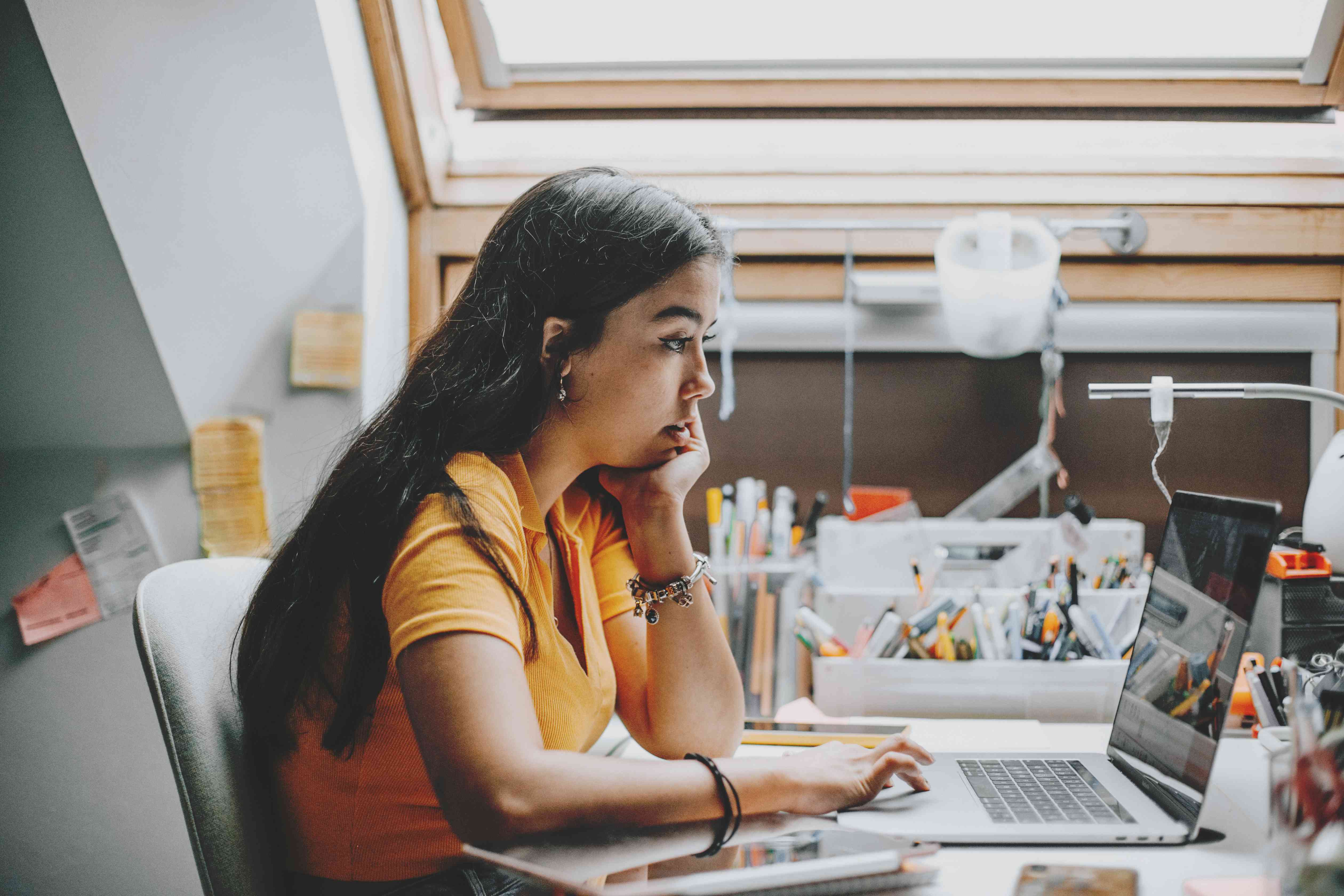 Teenager Working and Studying from Home Using Laptop