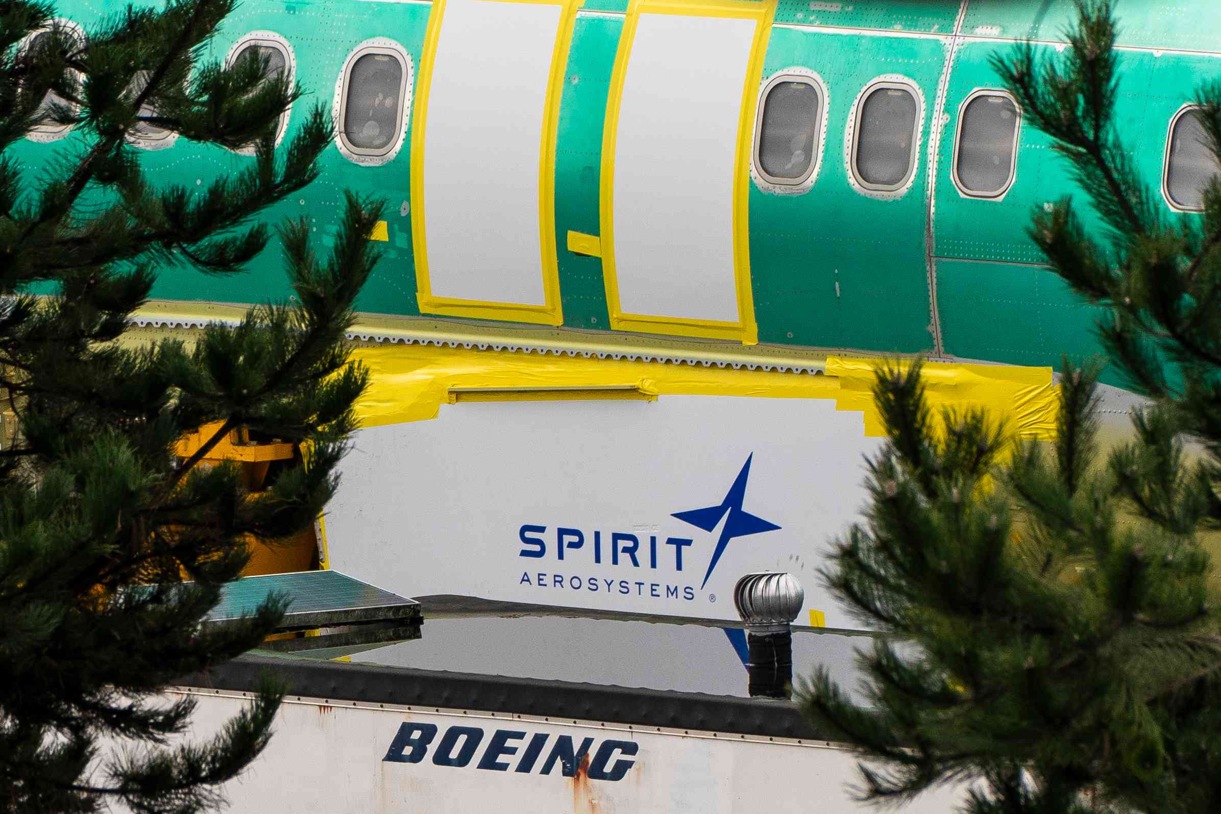 Spirit AeroSystems signage near a Boeing 737 Max 8 aircraft fuselage.