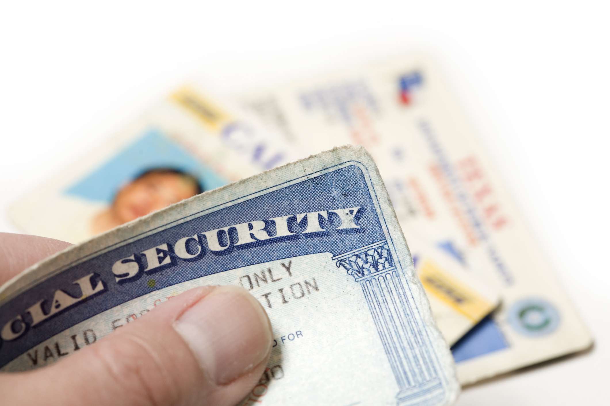 studio shot of hand holding social security card