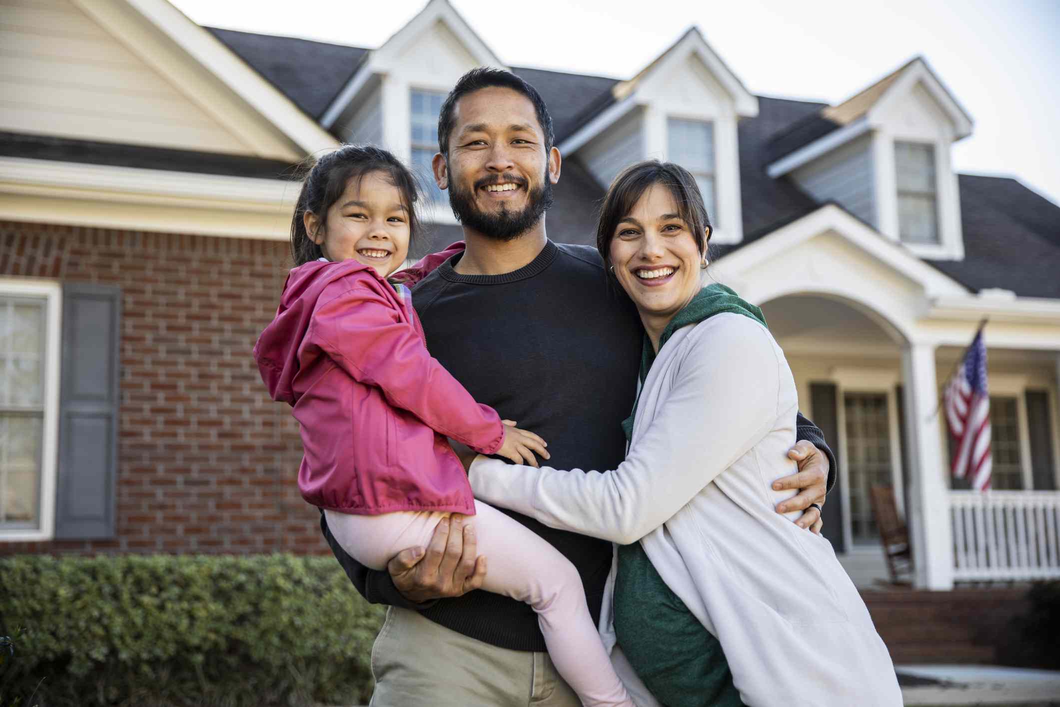 Portrait of a family in front of a suburban home