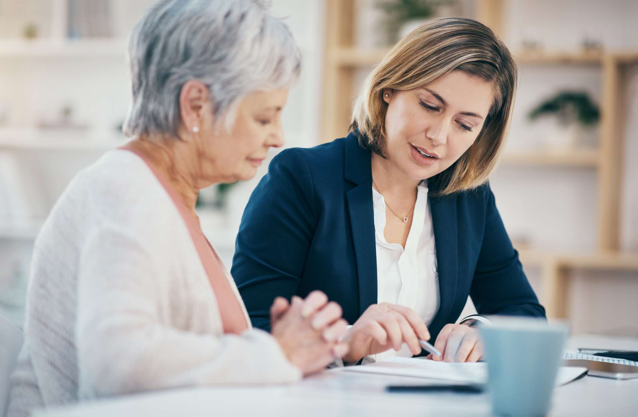 Two women review documents.