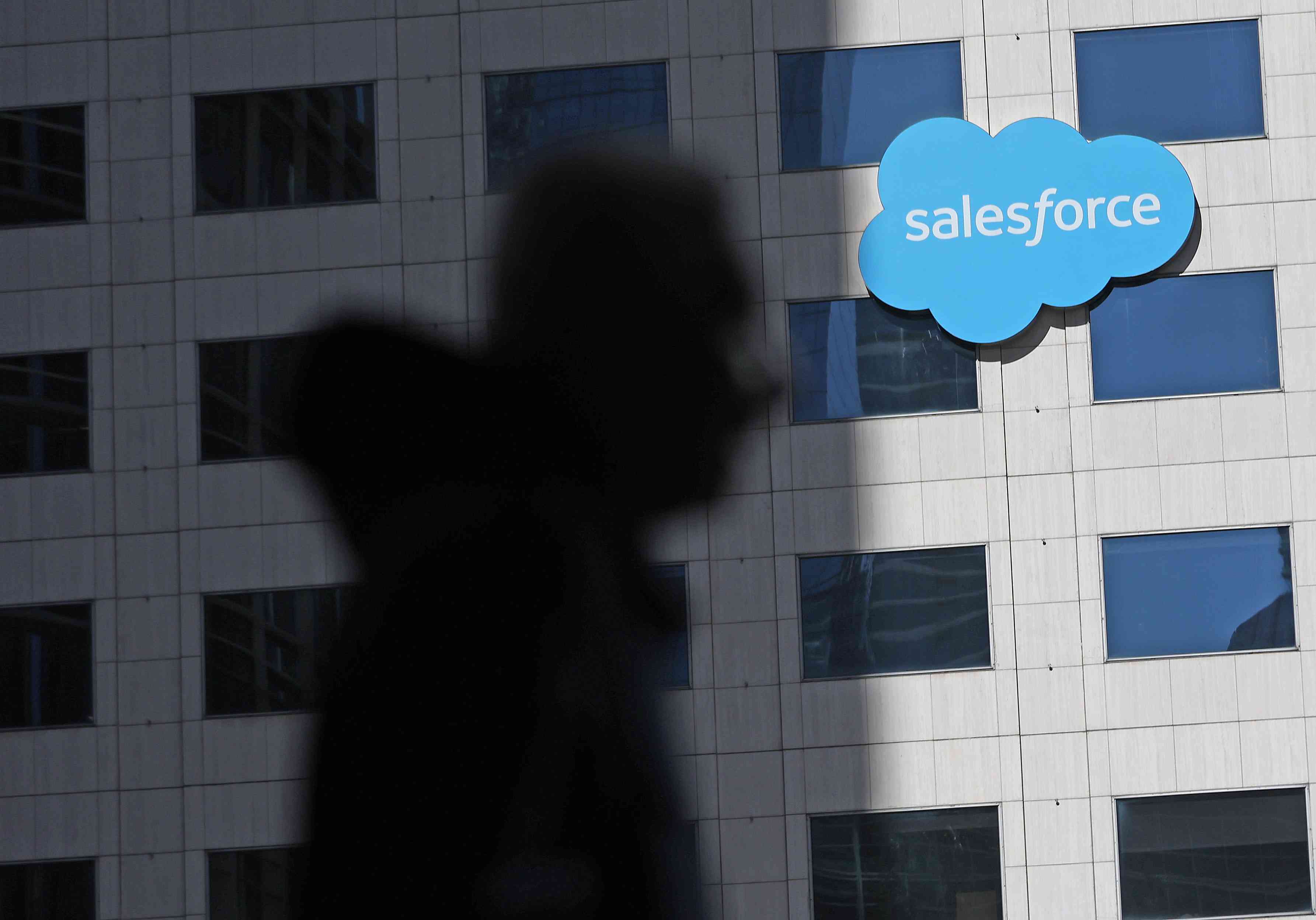 A person walks by the Salesforce headquarters. 