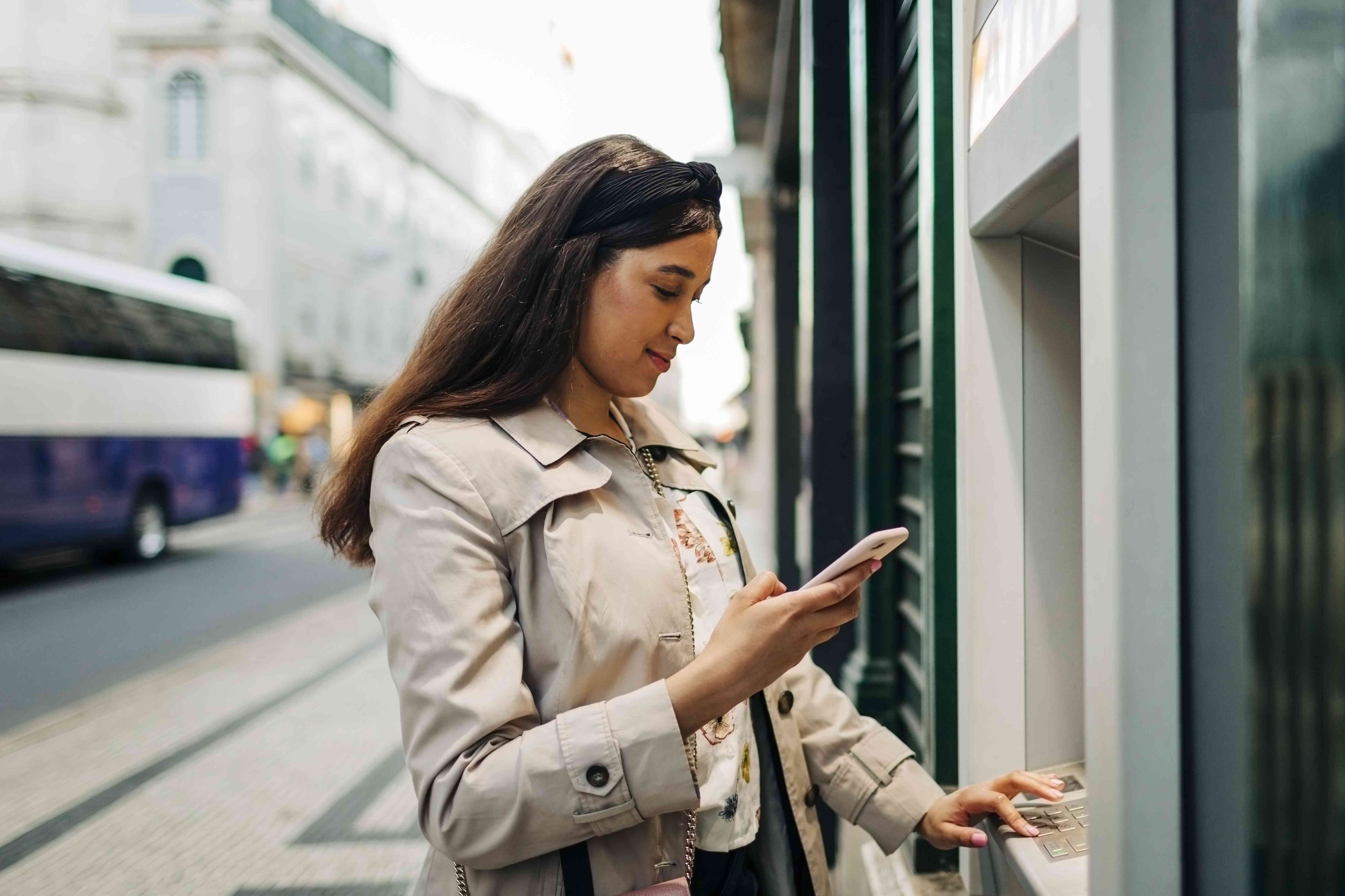 A woman uses an ATM machine.