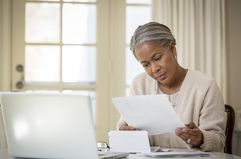 Woman reviews documents at a desk. 