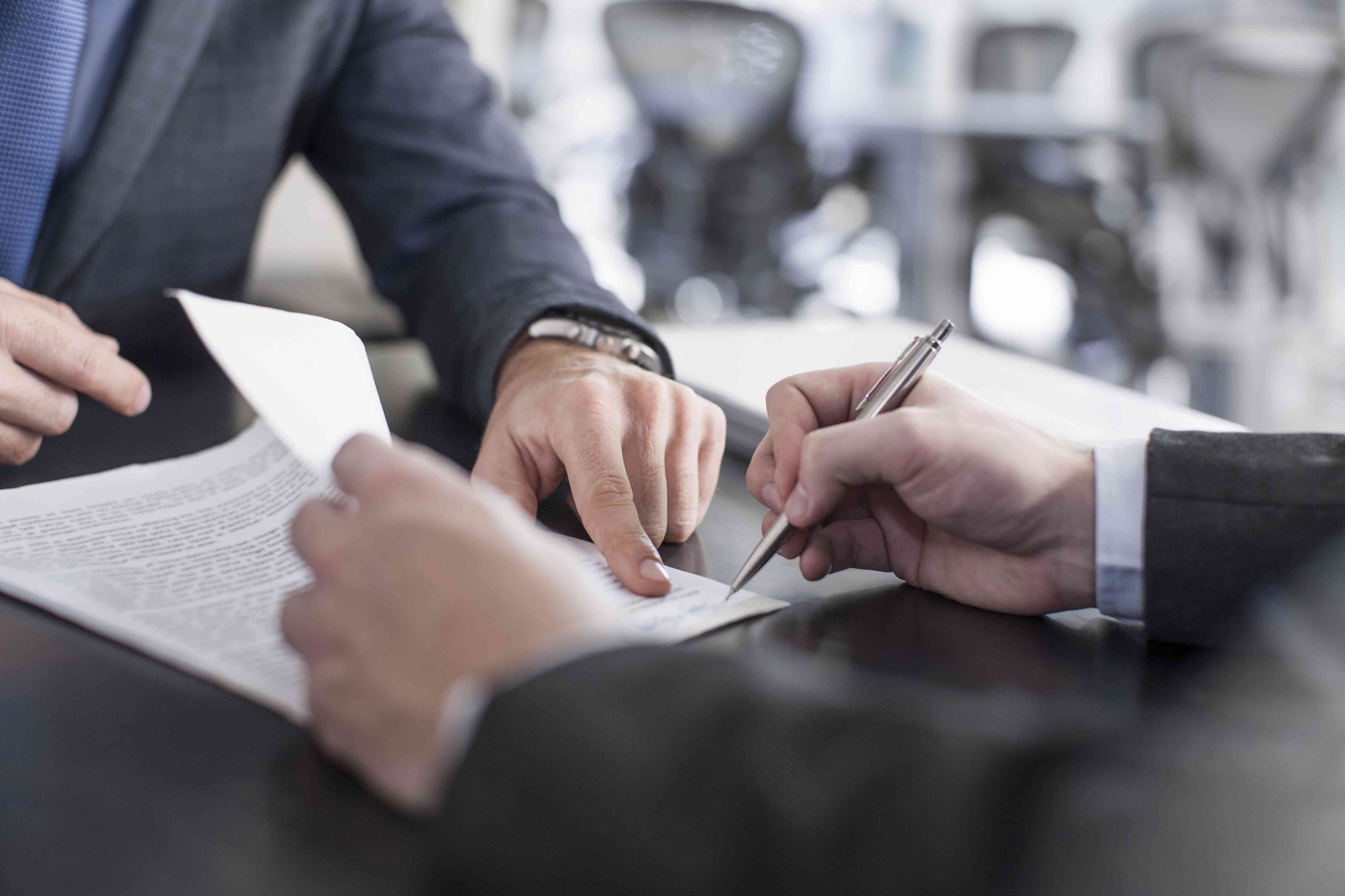 Businessman showing client where to sign document