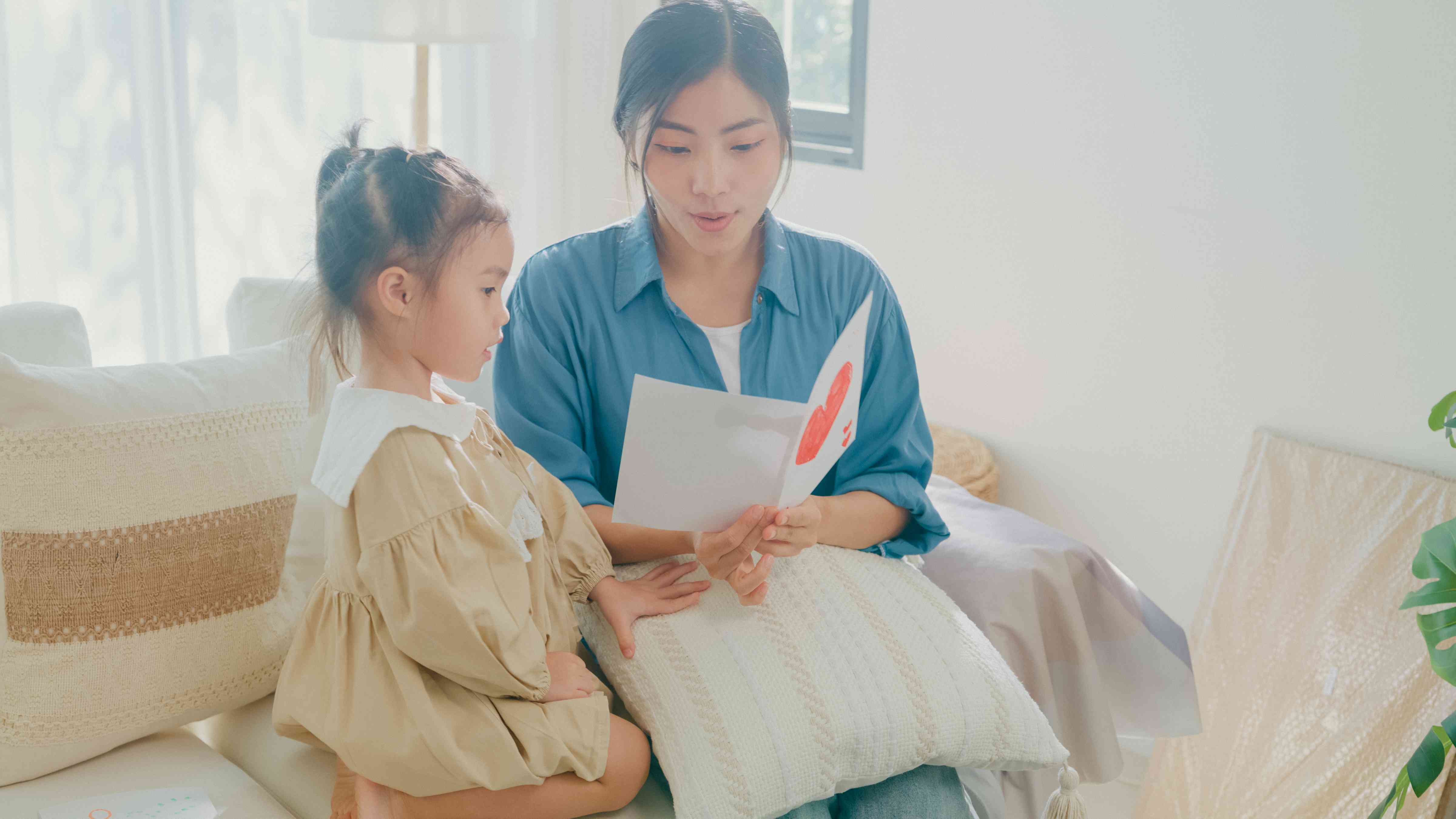 Mother reading a card to daughter