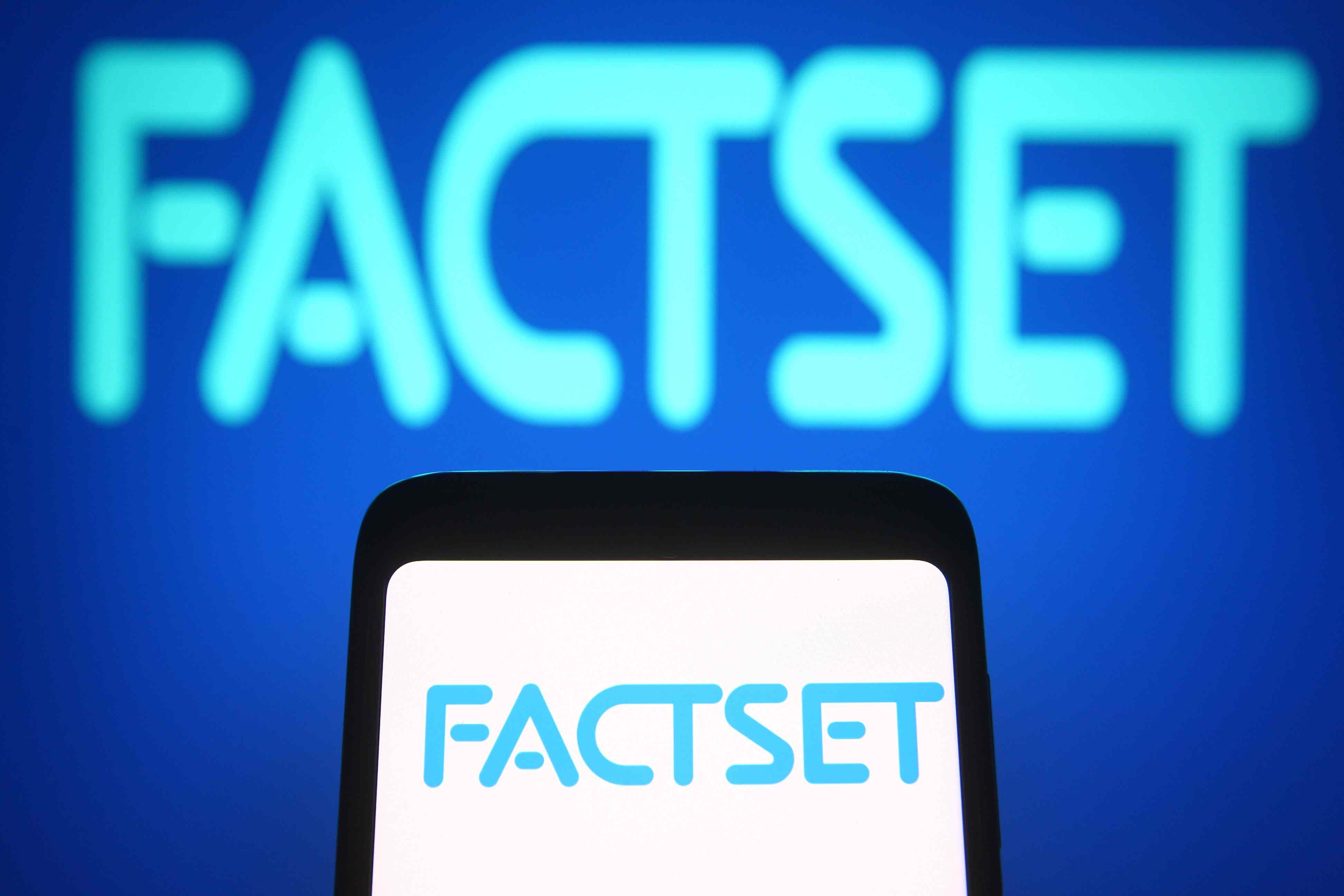 The FactSet logo is seen on a smartphone and a PC screen 