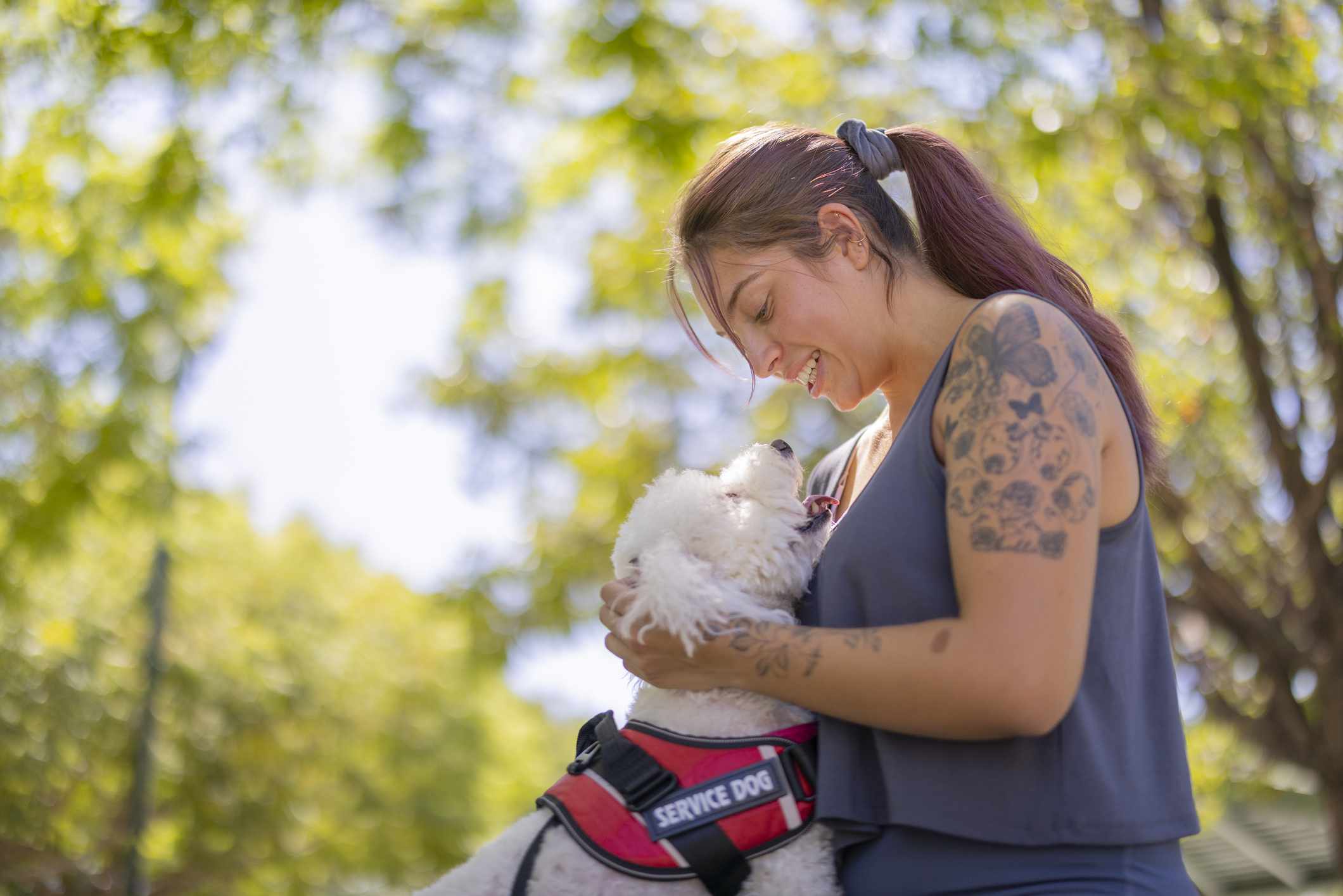 A woman with her service dog at the park.