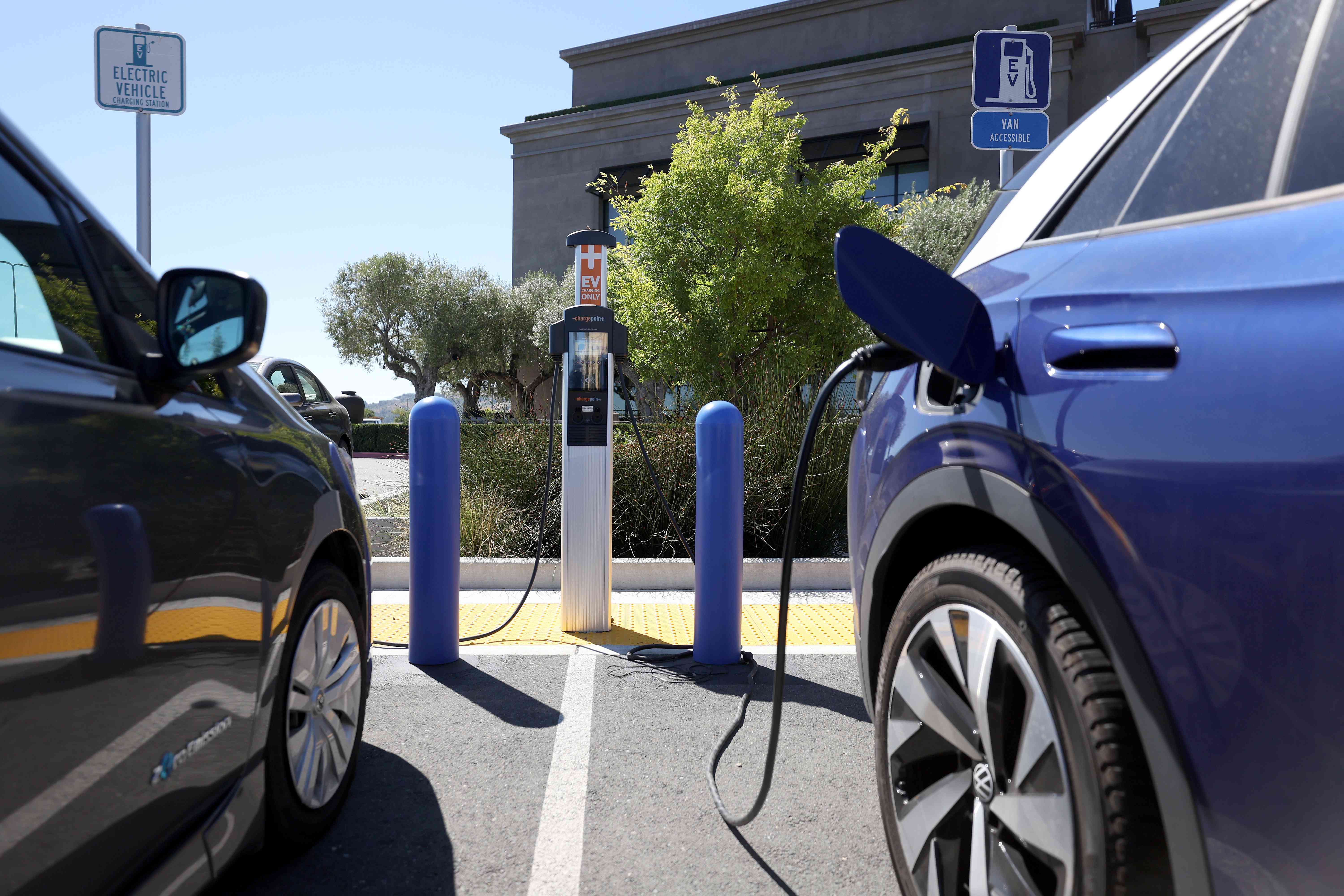 Nissan and Volkswagen electric cars sit parked at a Charge Point EV charging station on July 28, 2023 in Corte Madera, California.