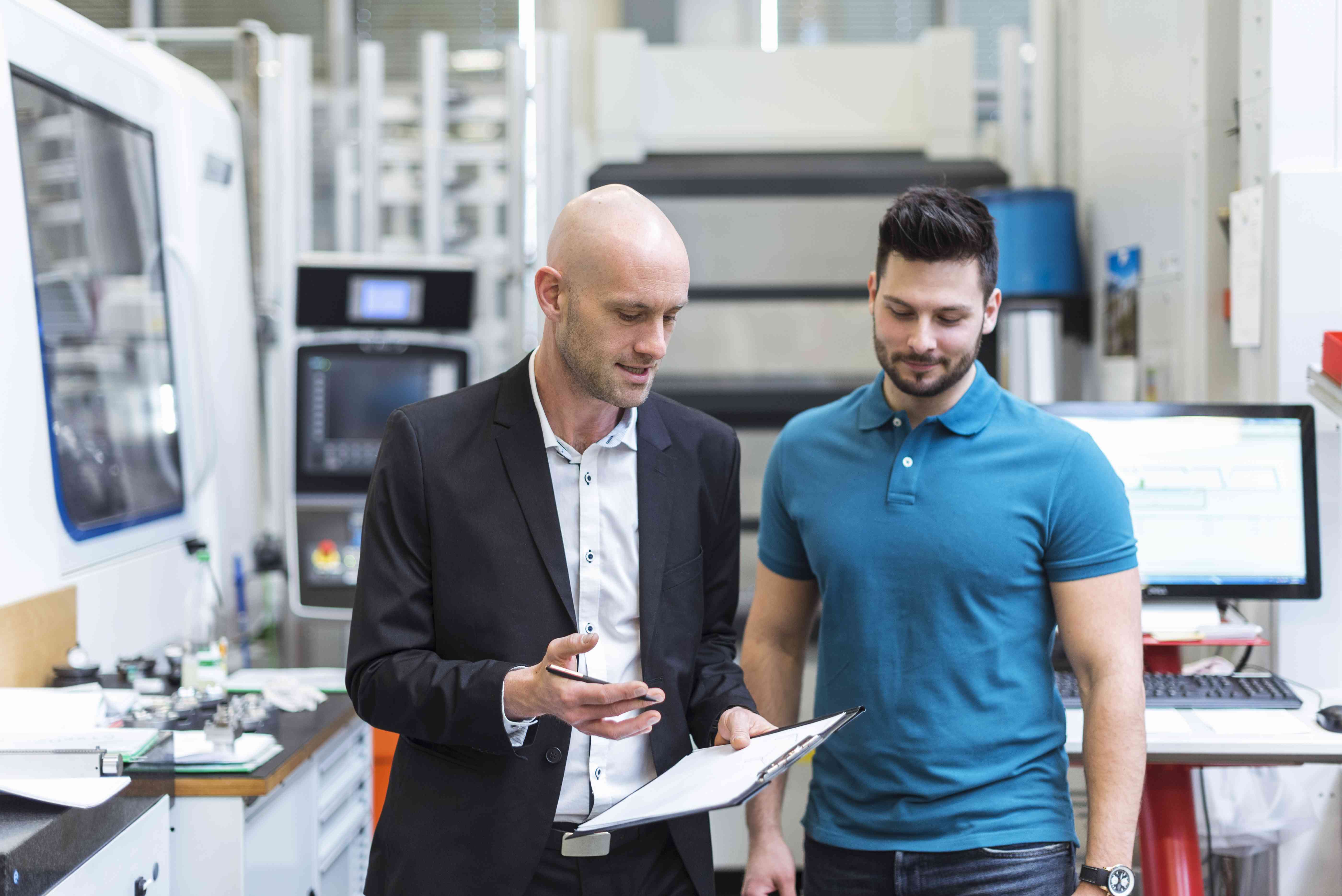 Businessman and employee discussing in modern factory