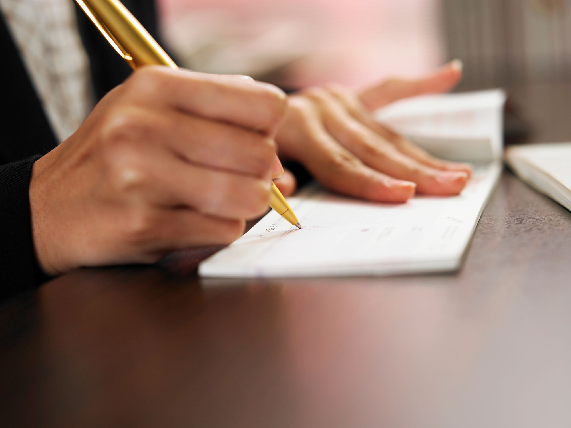 A woman writes a personal check